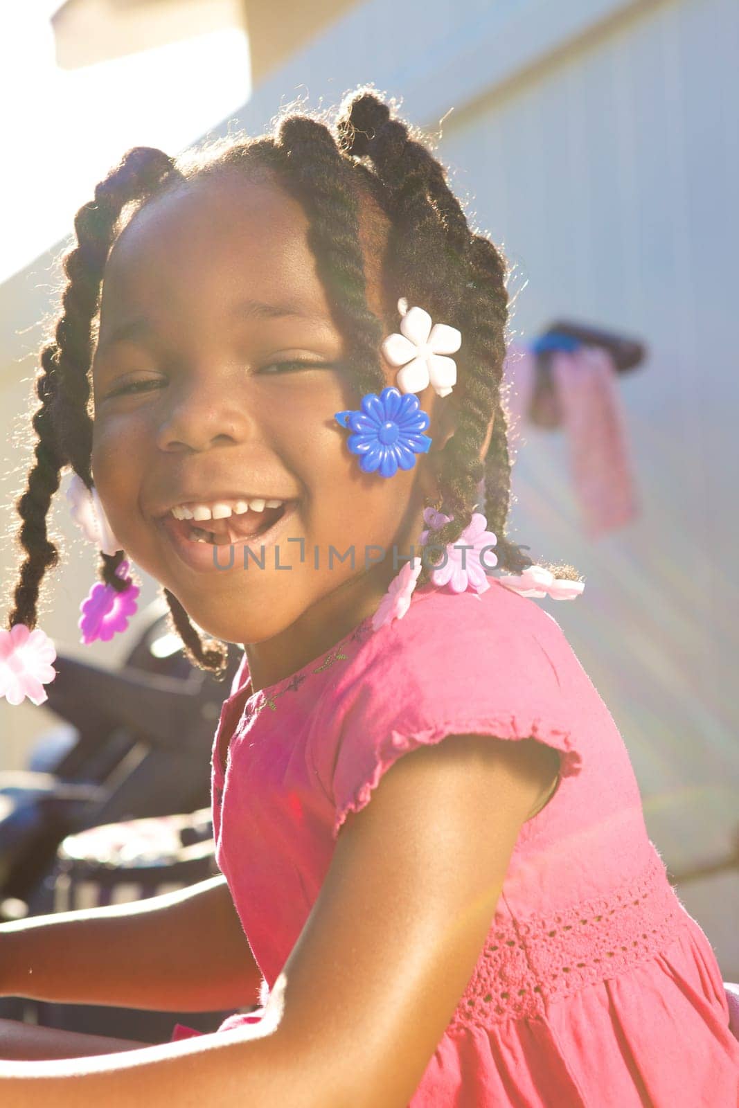 An adorable little african american girl in a pink shirt