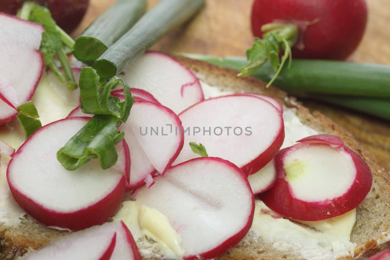 Fresh radish bread with spring leek as background