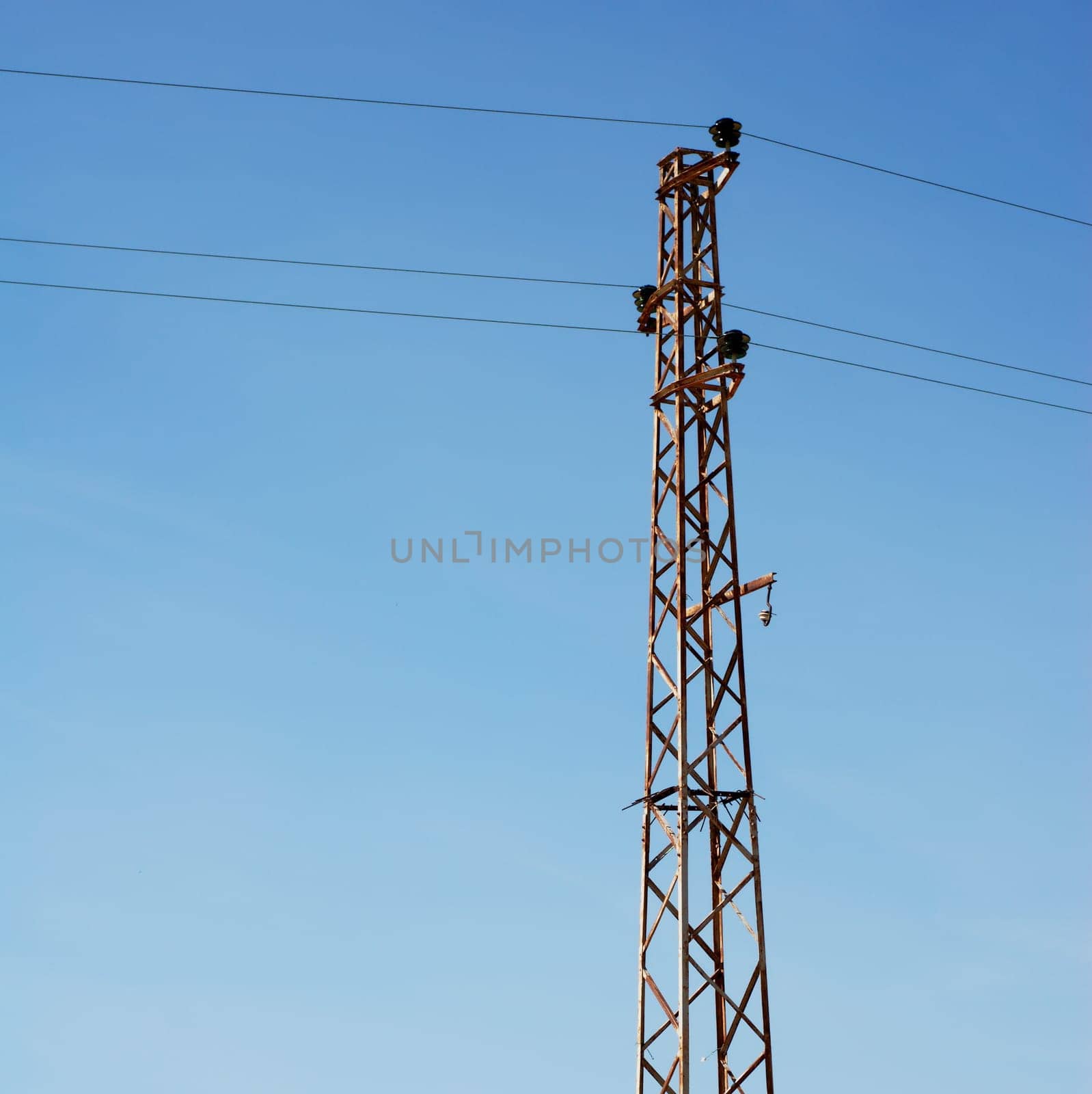 Old rusty electical pylon and blue sky
