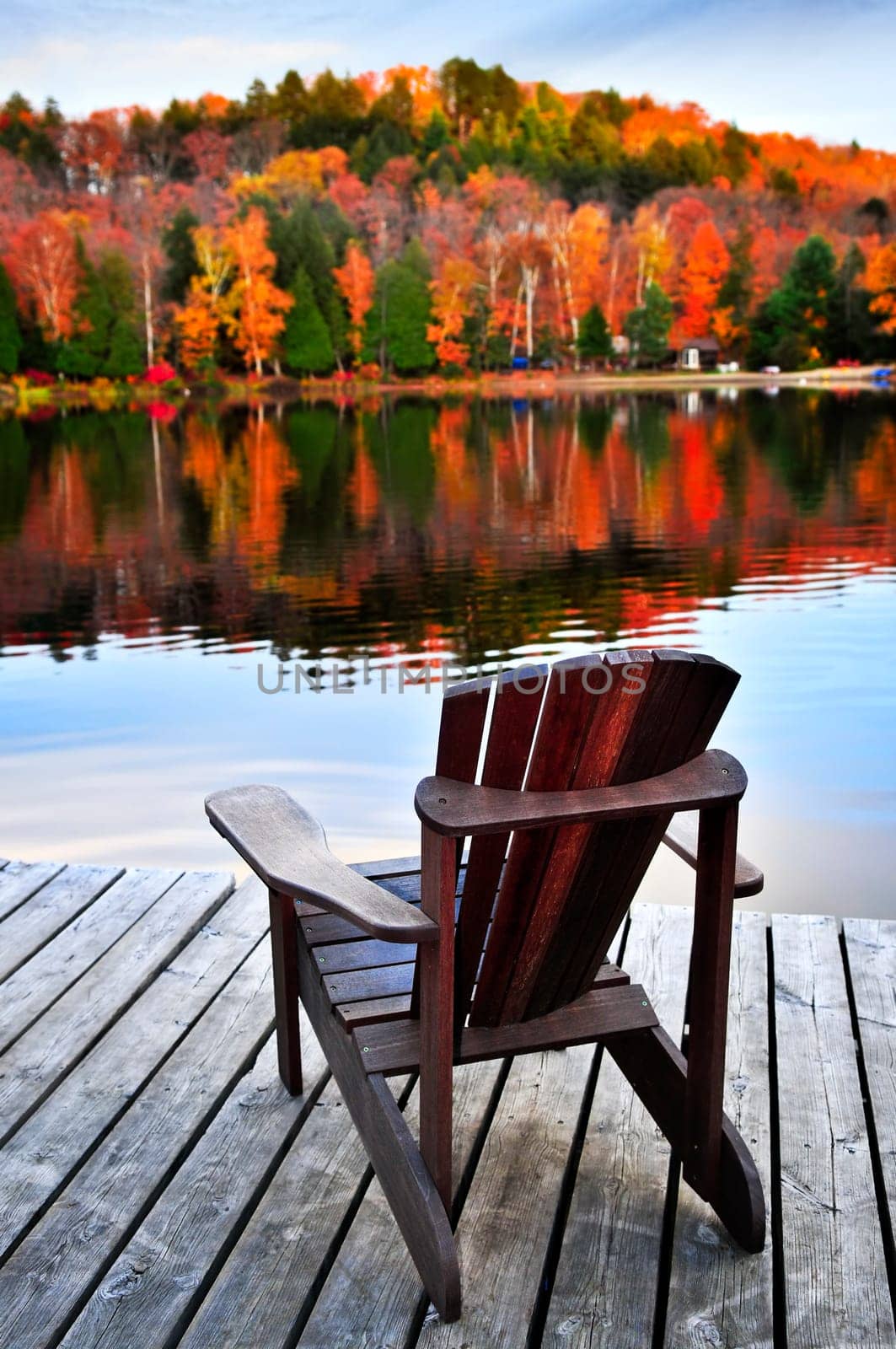 Wooden dock with chair on calm fall lake