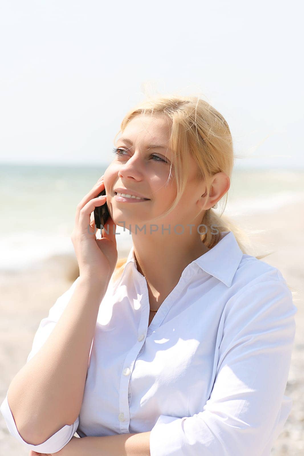 business woman talks by phone on a beach
