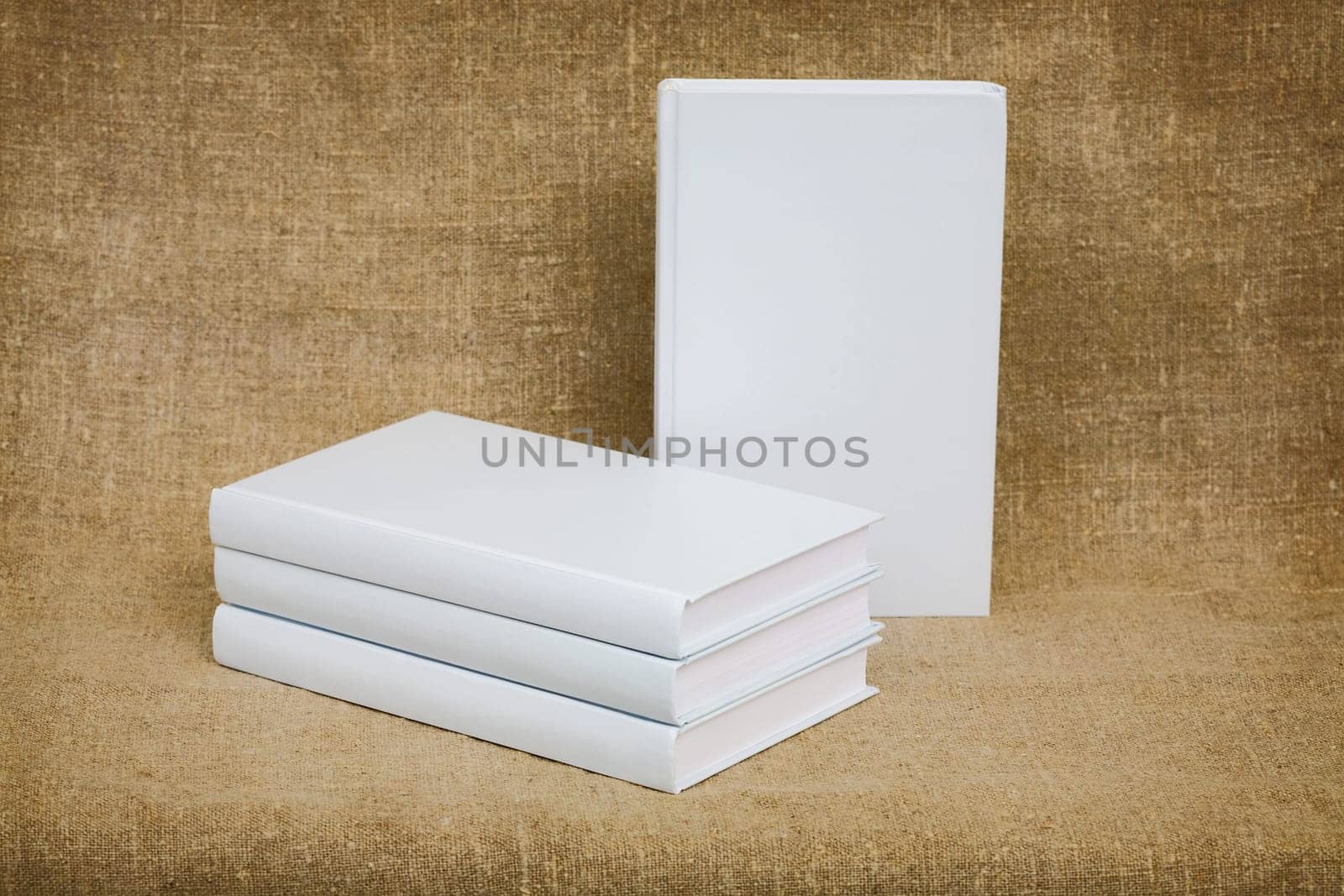 Still-life from several books with white cover on canvas background