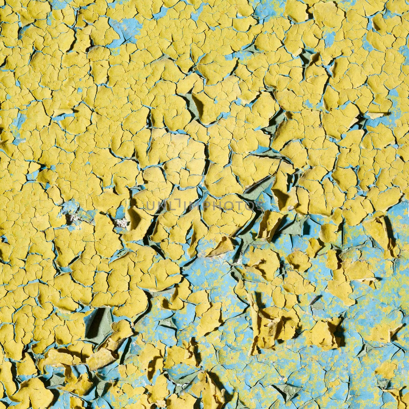 Old grunge yellow wall with cracks and stains