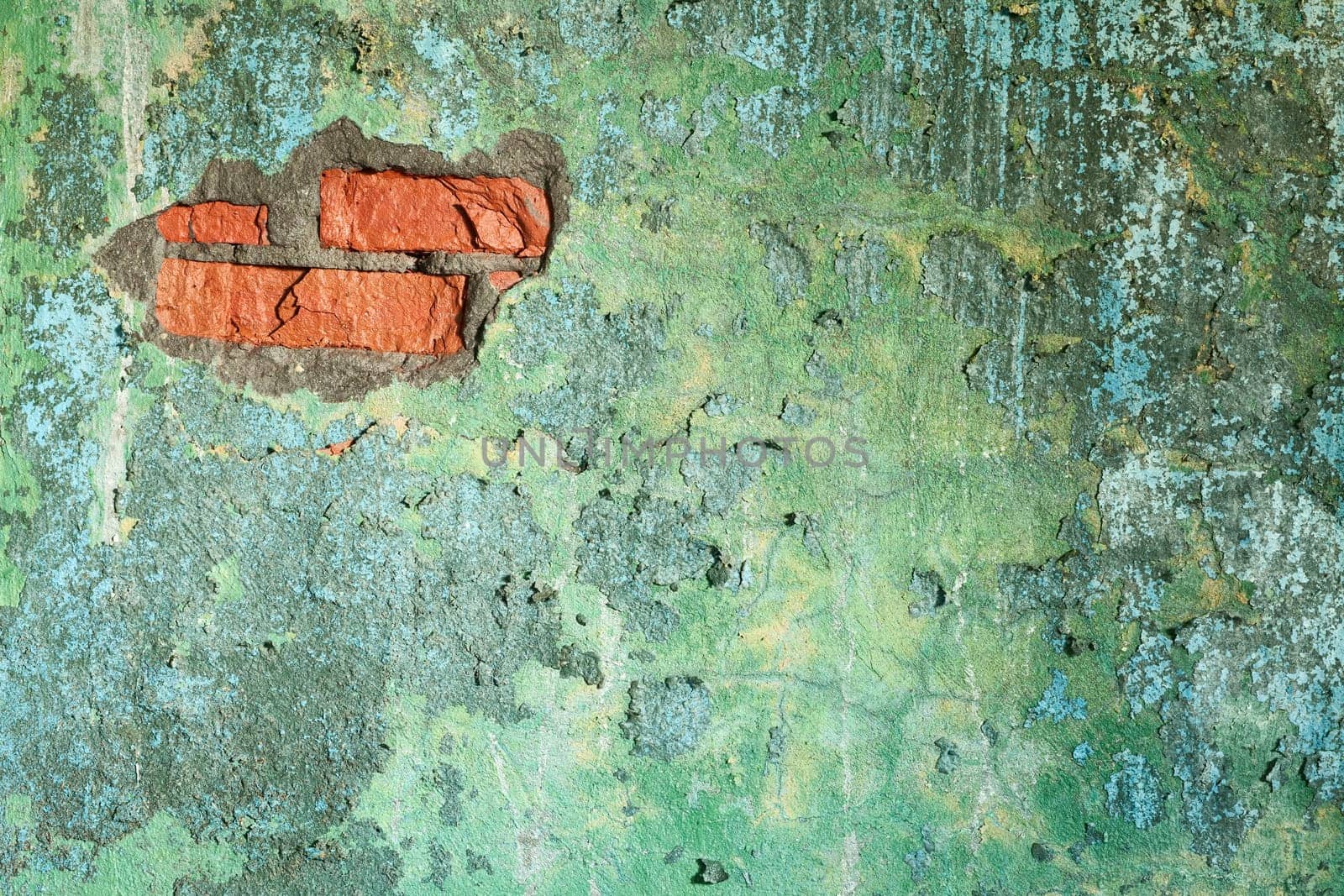 Damaged painted old brick wall with hole