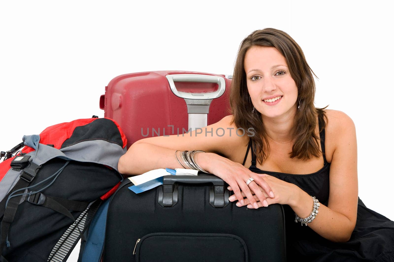 Young brunette posing amidst her luggage, smiling