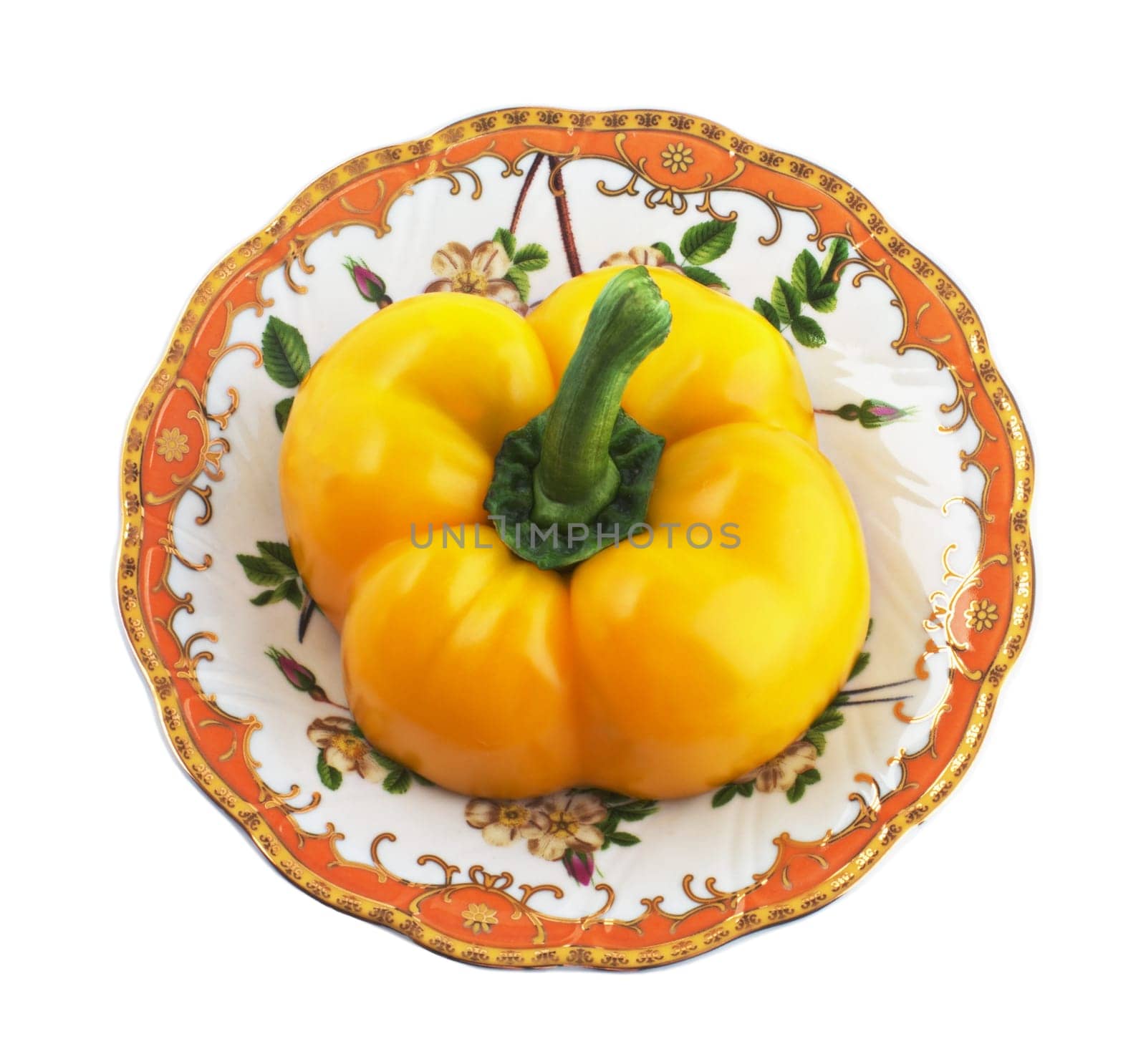 Half of yellow pepper on a patterned saucer
