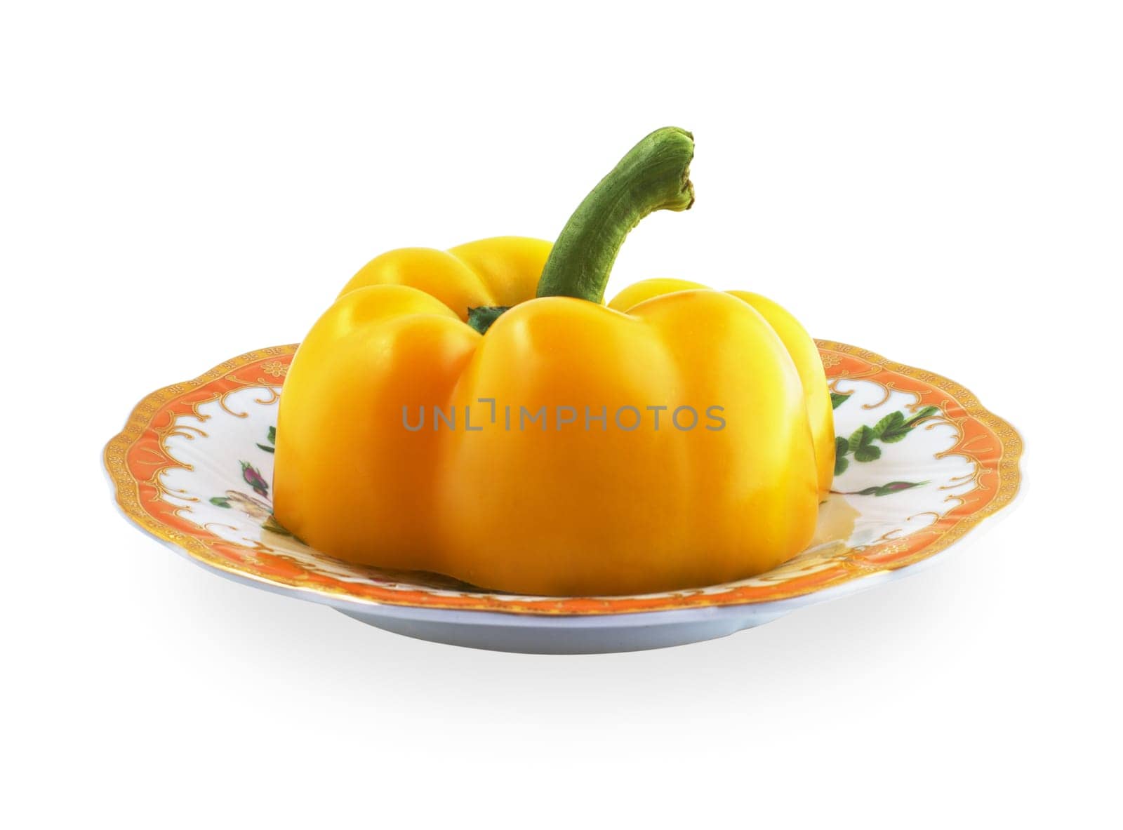 Half of yellow pepper on a patterned saucer