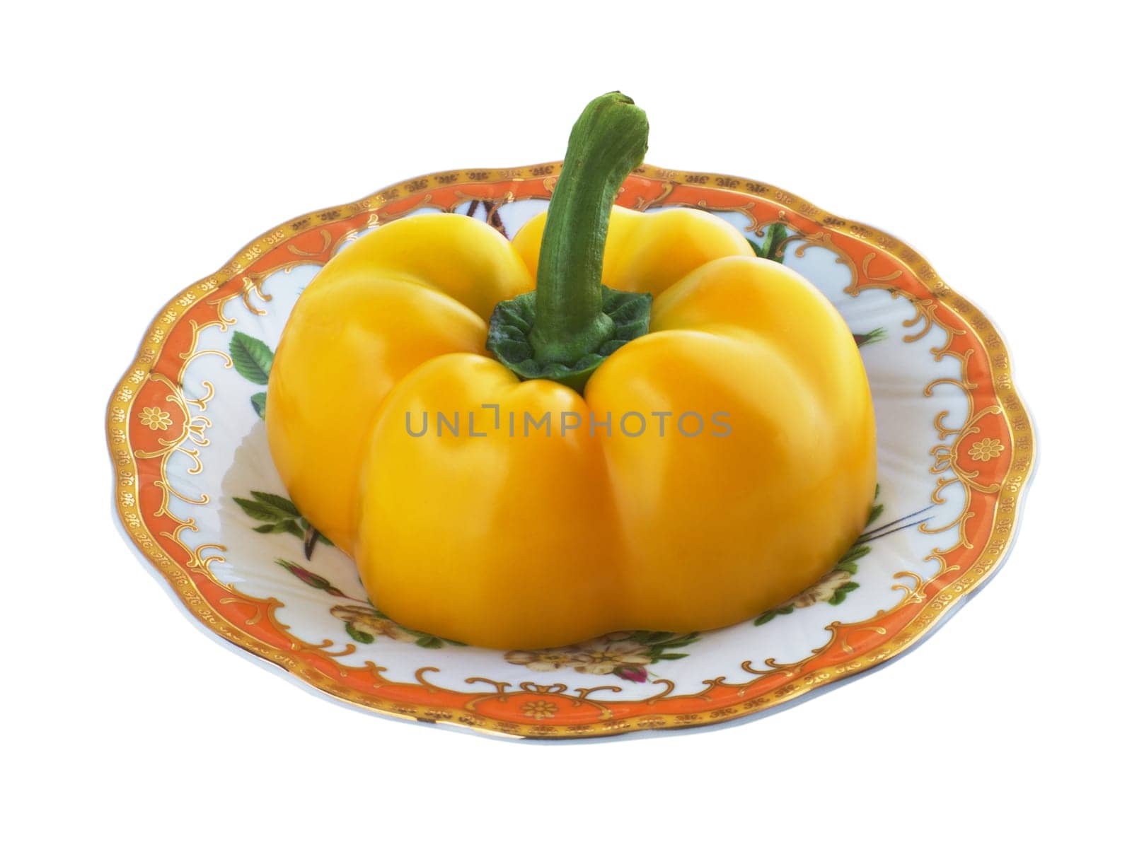Half of yellow pepper on a patterned saucer