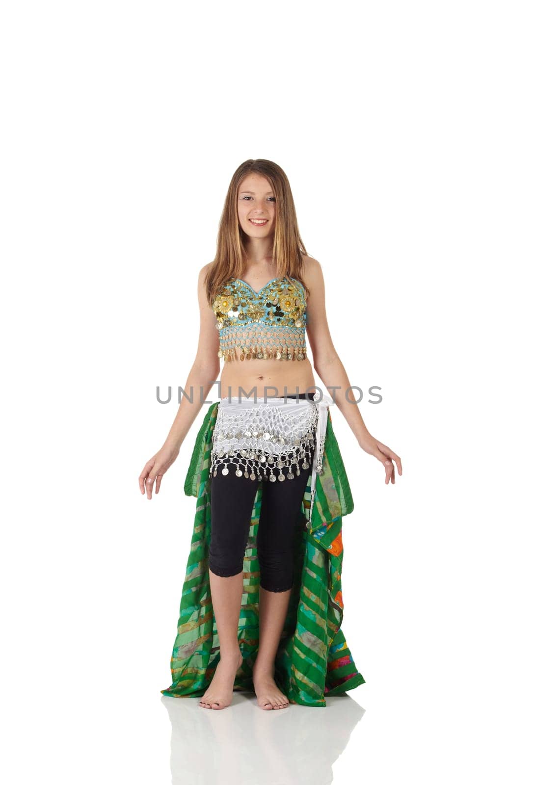 Young Caucasian belly dancing girl in beautiful decorated clothes on white background and reflective floor. Not isolated
