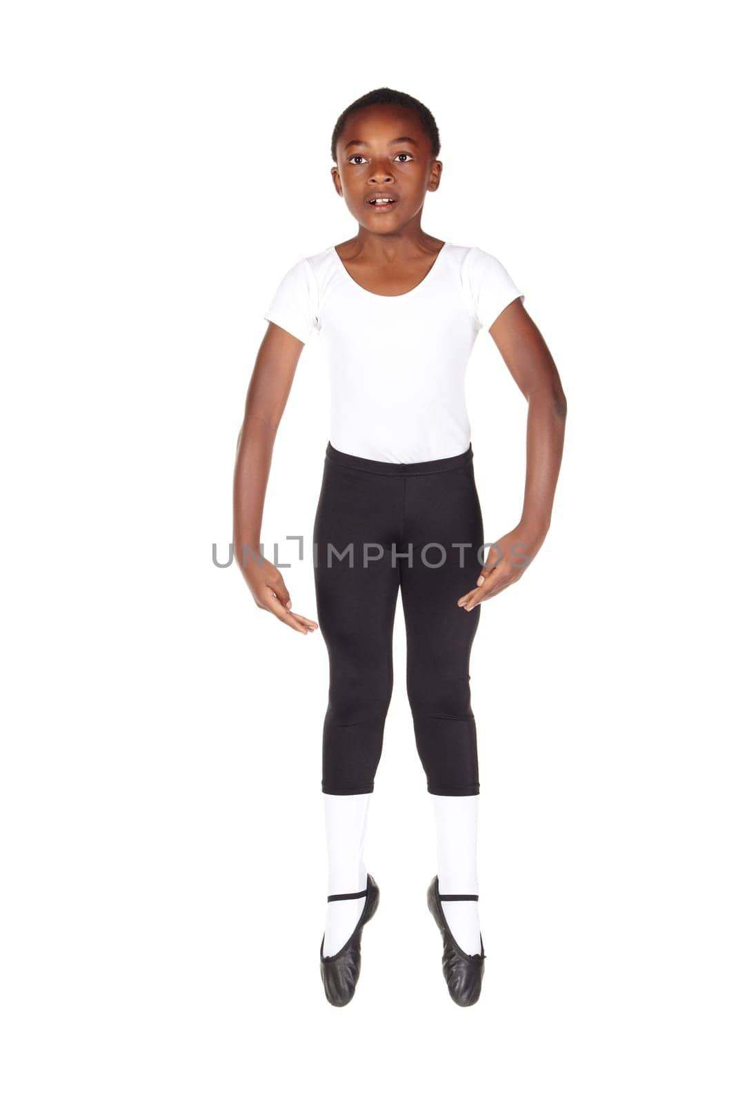 Young African ballet boy on white background and floor showing various ballet steps and positions. Not Isolated