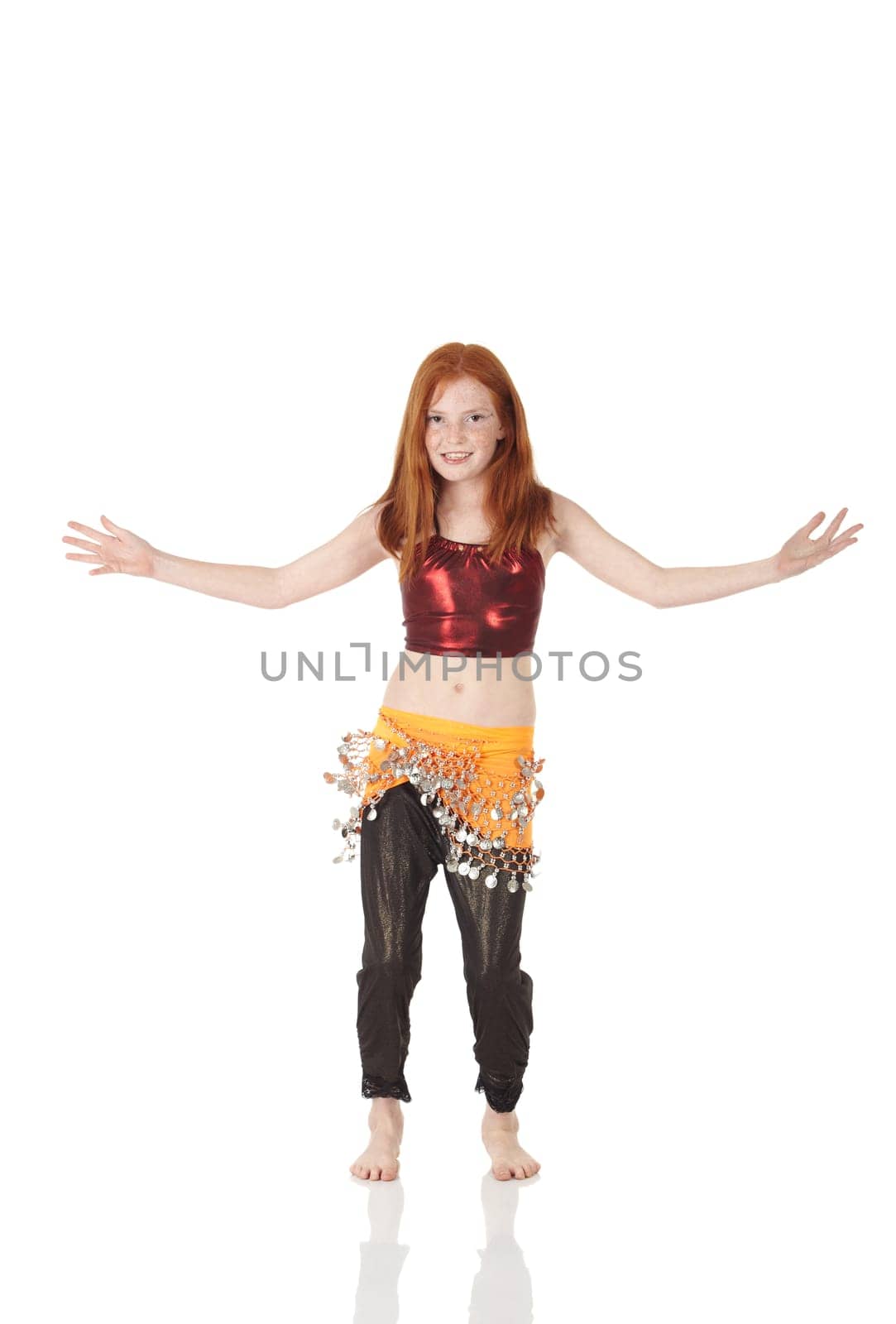 Young Caucasian belly dancing girl in beautiful decorated clothes on white background and reflective floor. Not isolated