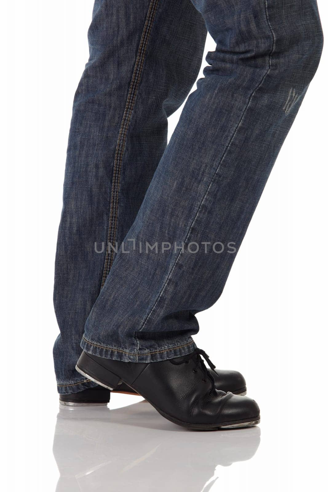 Single male tap dancer wearing jeans showing various steps in studio with white background and reflective floor. Not isolated