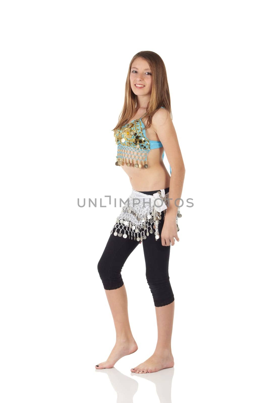 Young Caucasian belly dancing girl in beautiful decorated clothes on white background and reflective floor. Not isolated