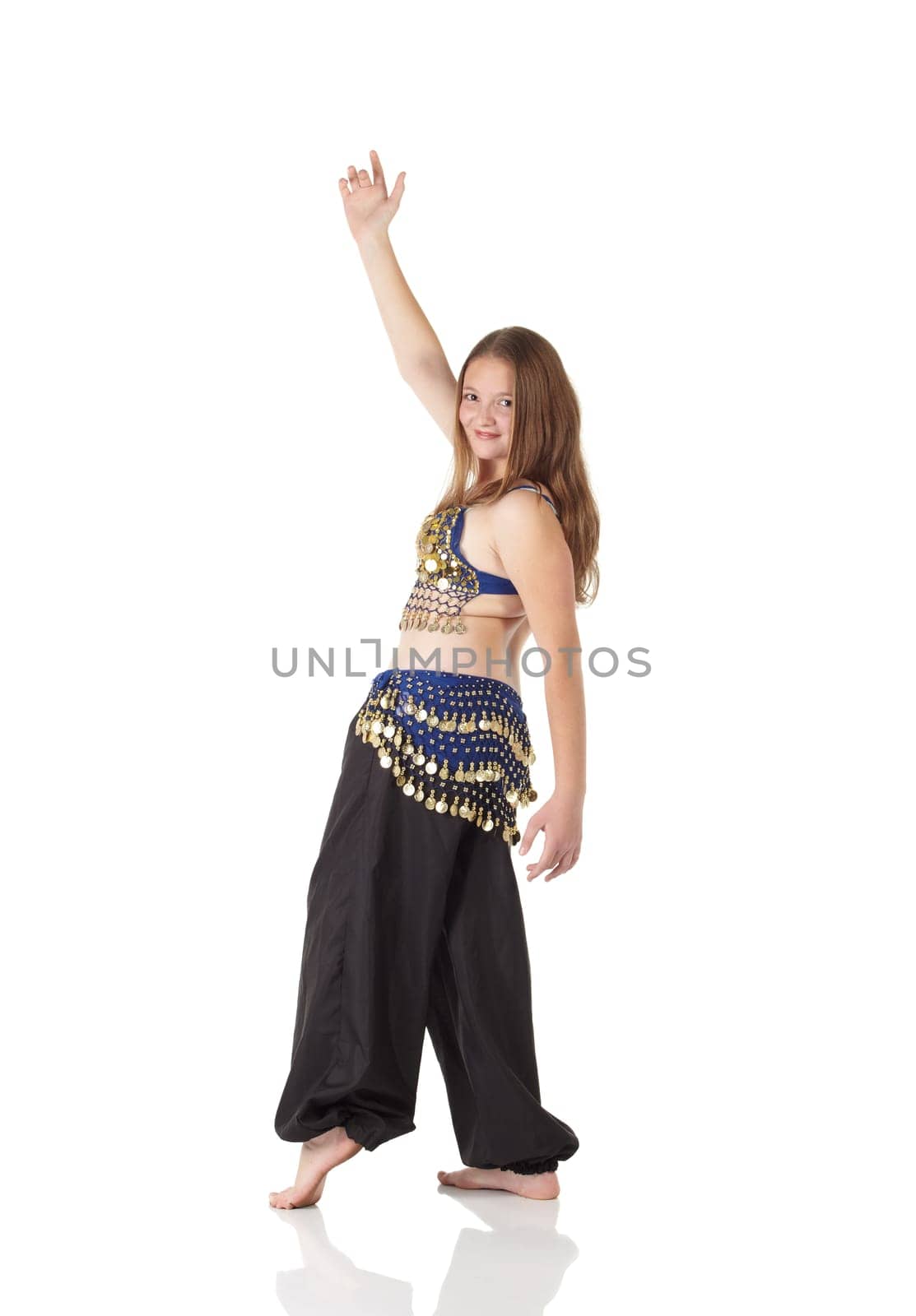Young Caucasian belly dancing girl in beautiful decorated clothes on white background and reflective floor. Not isolated