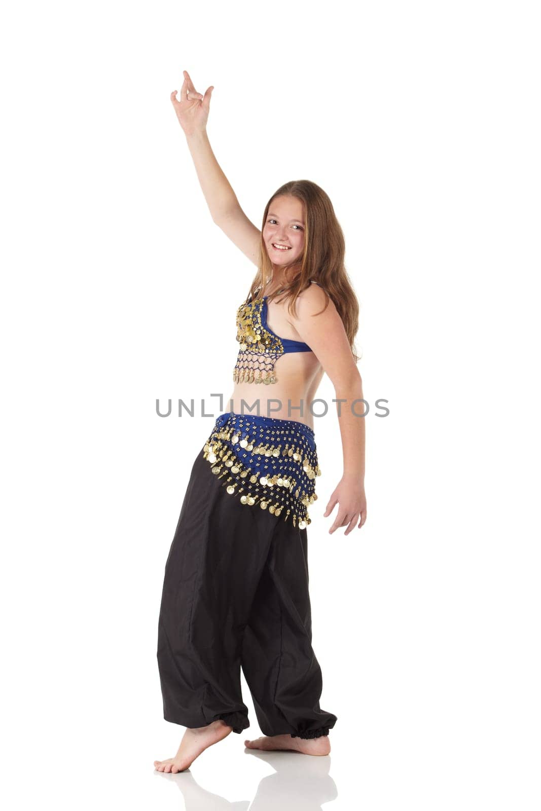 Young Caucasian belly dancing girl in beautiful decorated clothes on white background and reflective floor. Not isolated