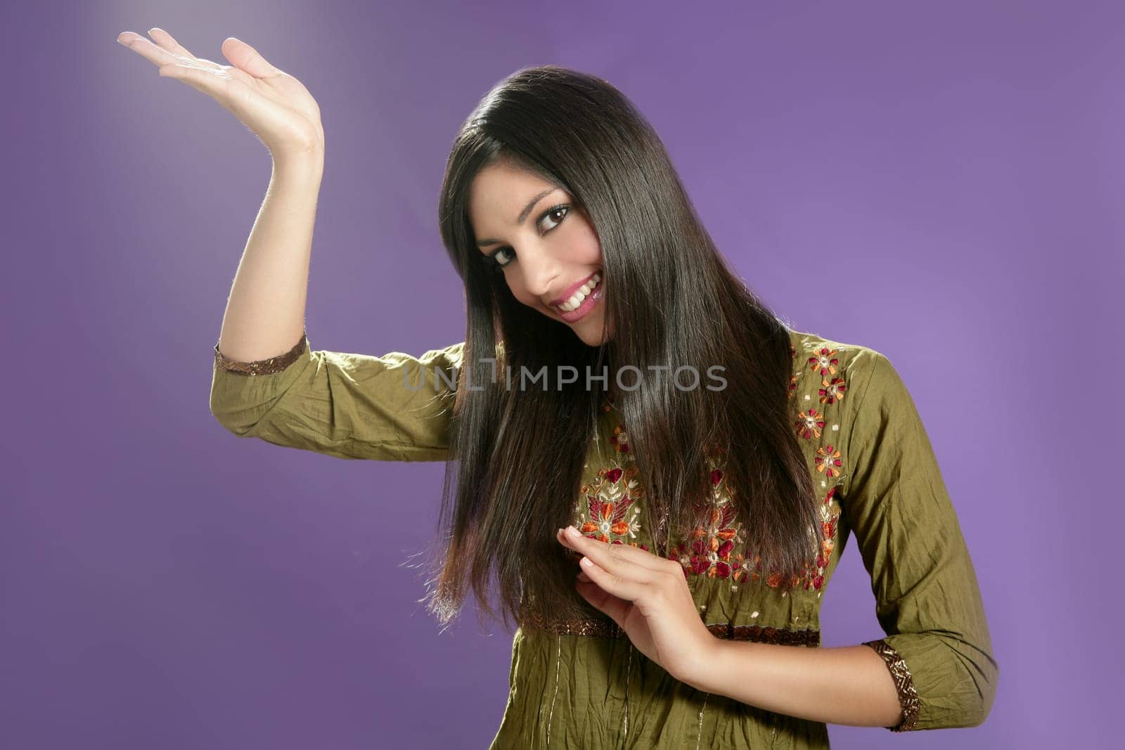Beautiful indian young brunette woman posing hands on purple background
