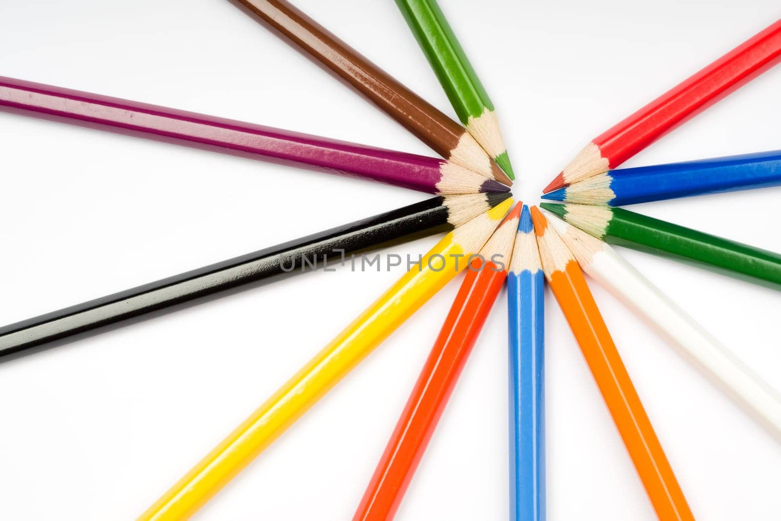 Assortment of coloured pencils with shadow on white background