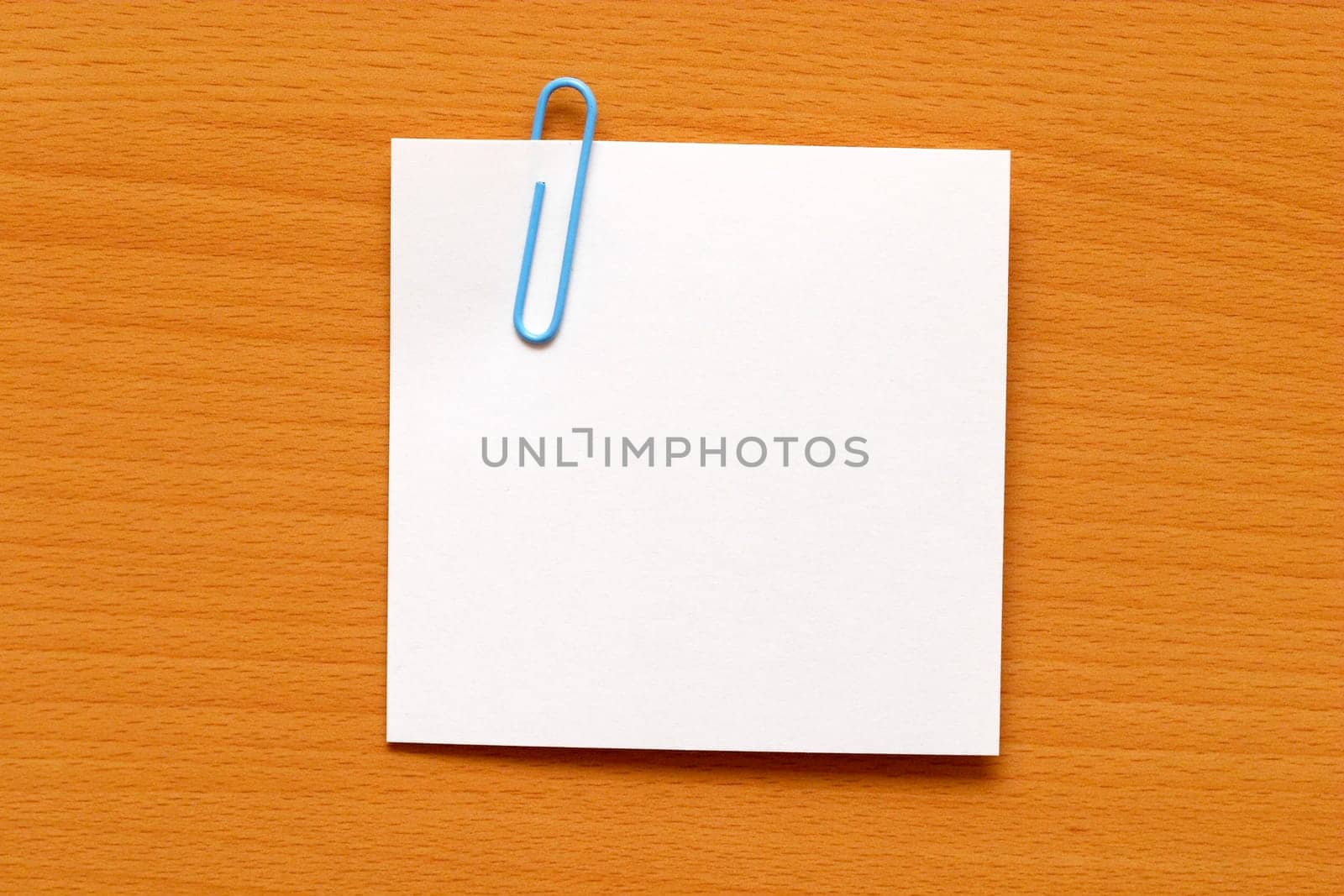 Paper note with a blue clip over the wooden table
