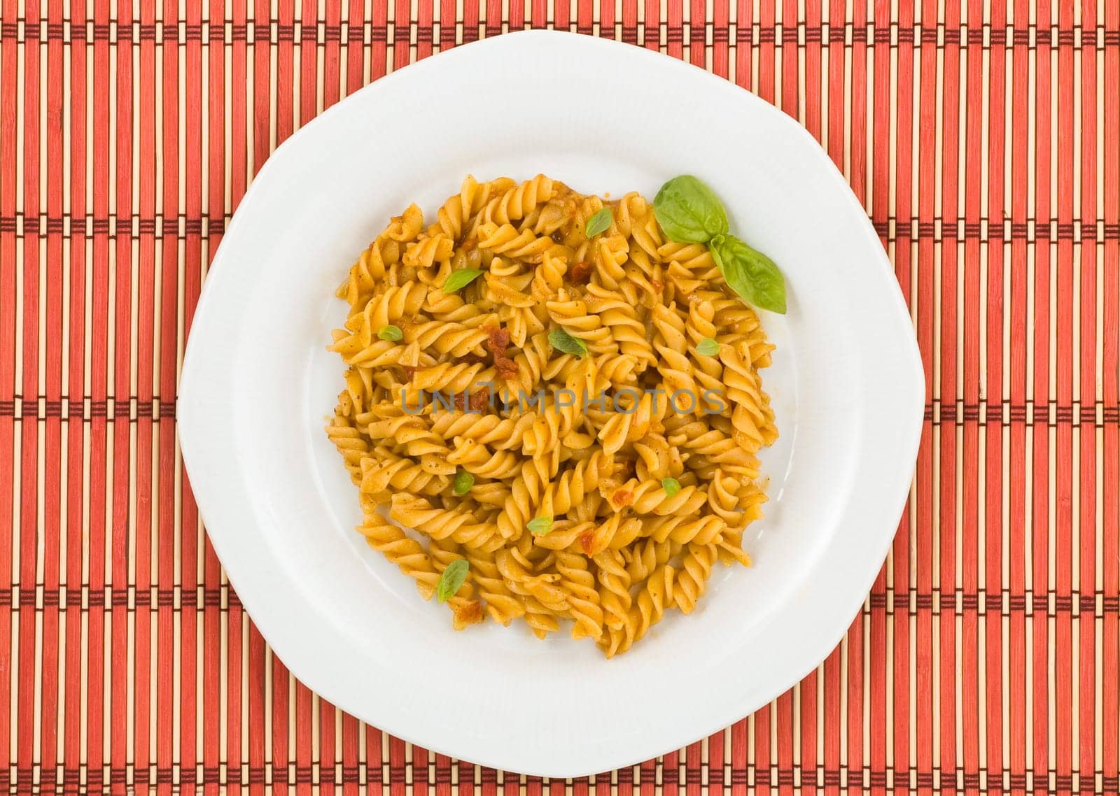 Italian pasta, fusilli, with tomato sauce and basil.