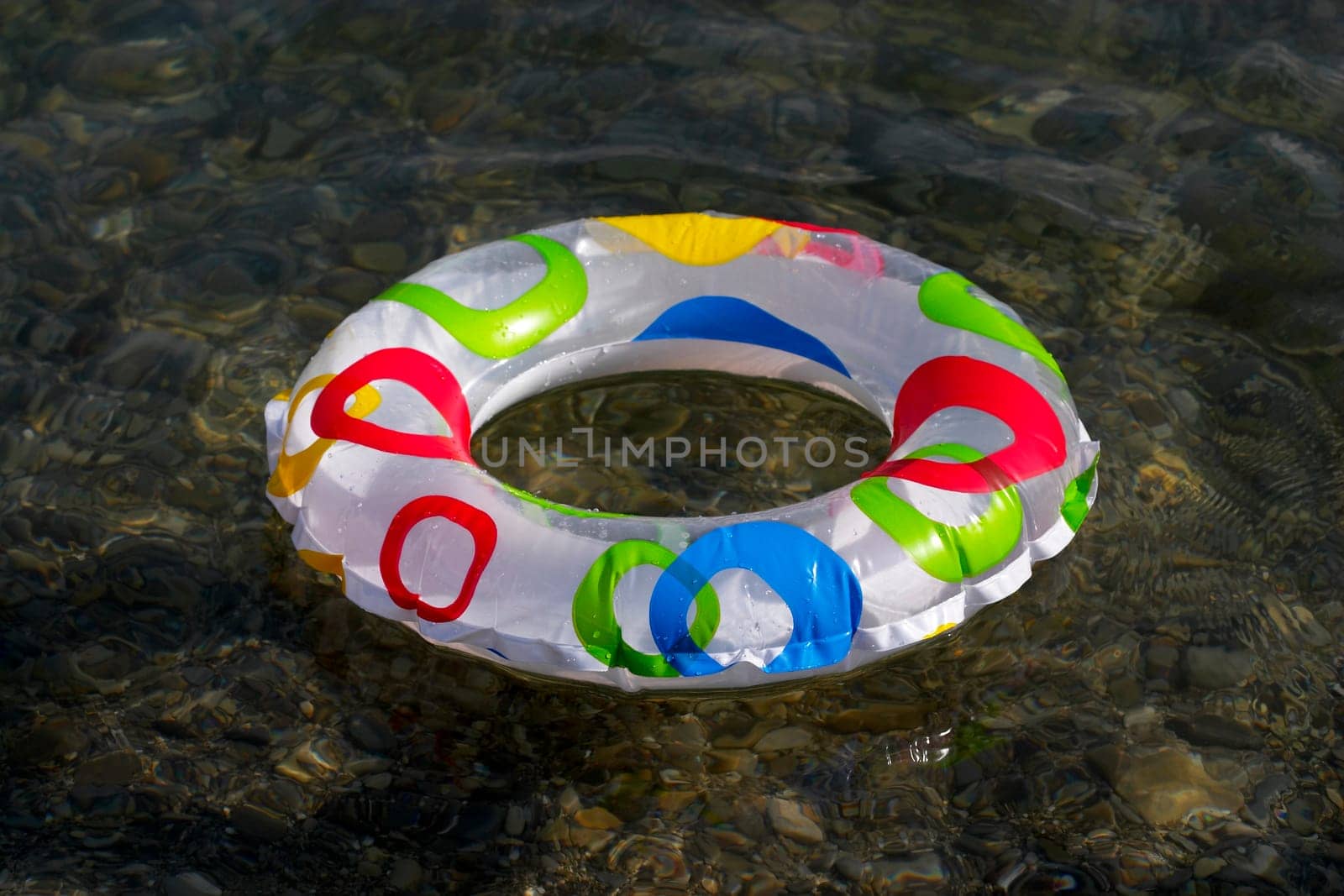 Inflatable ring floating on the sea, transparent clear water