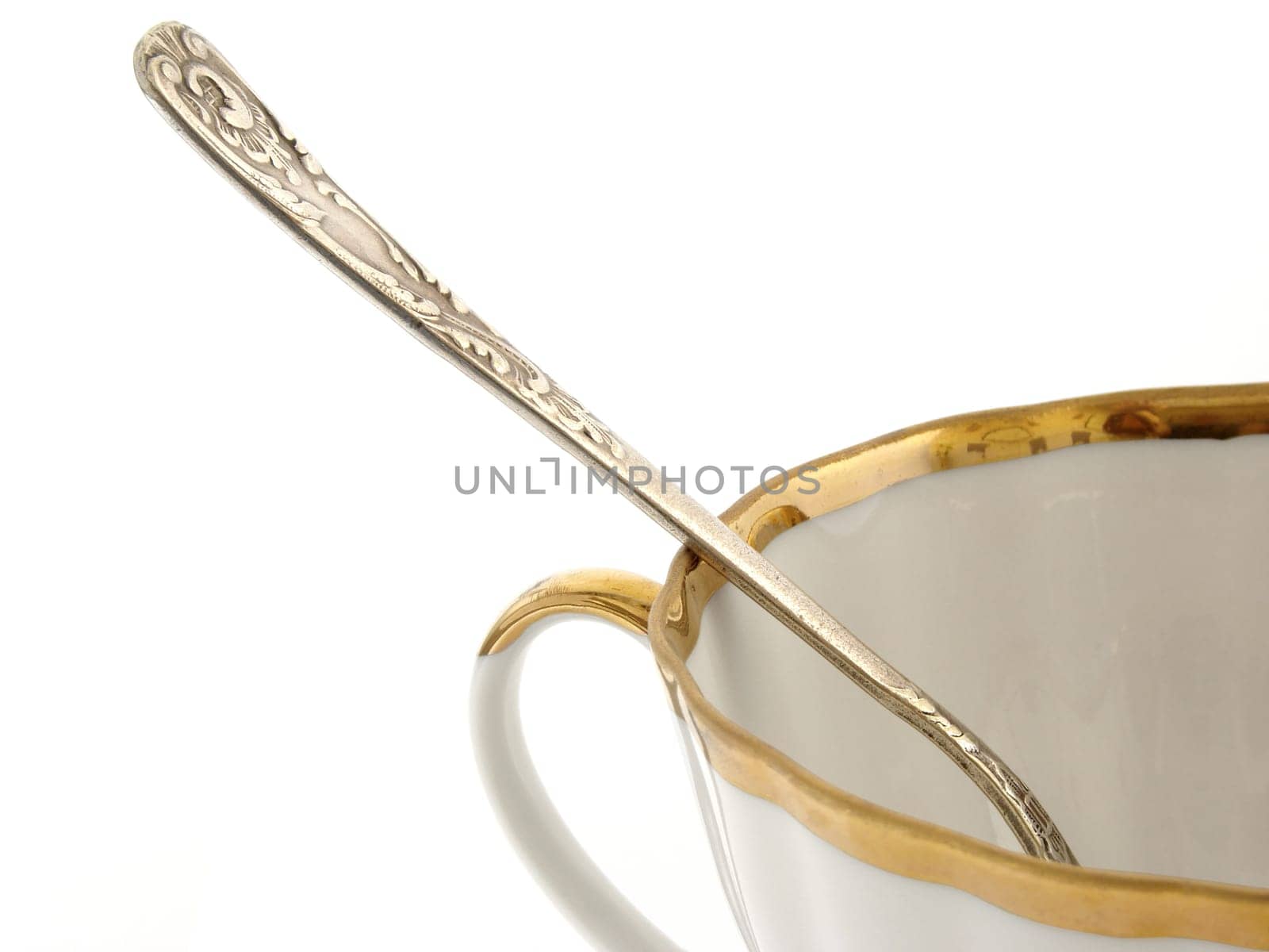 teacup with teaspoon fragment on white