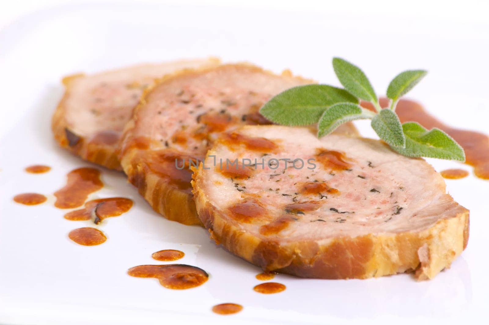 Three slice of roasted meat with sage and garnish