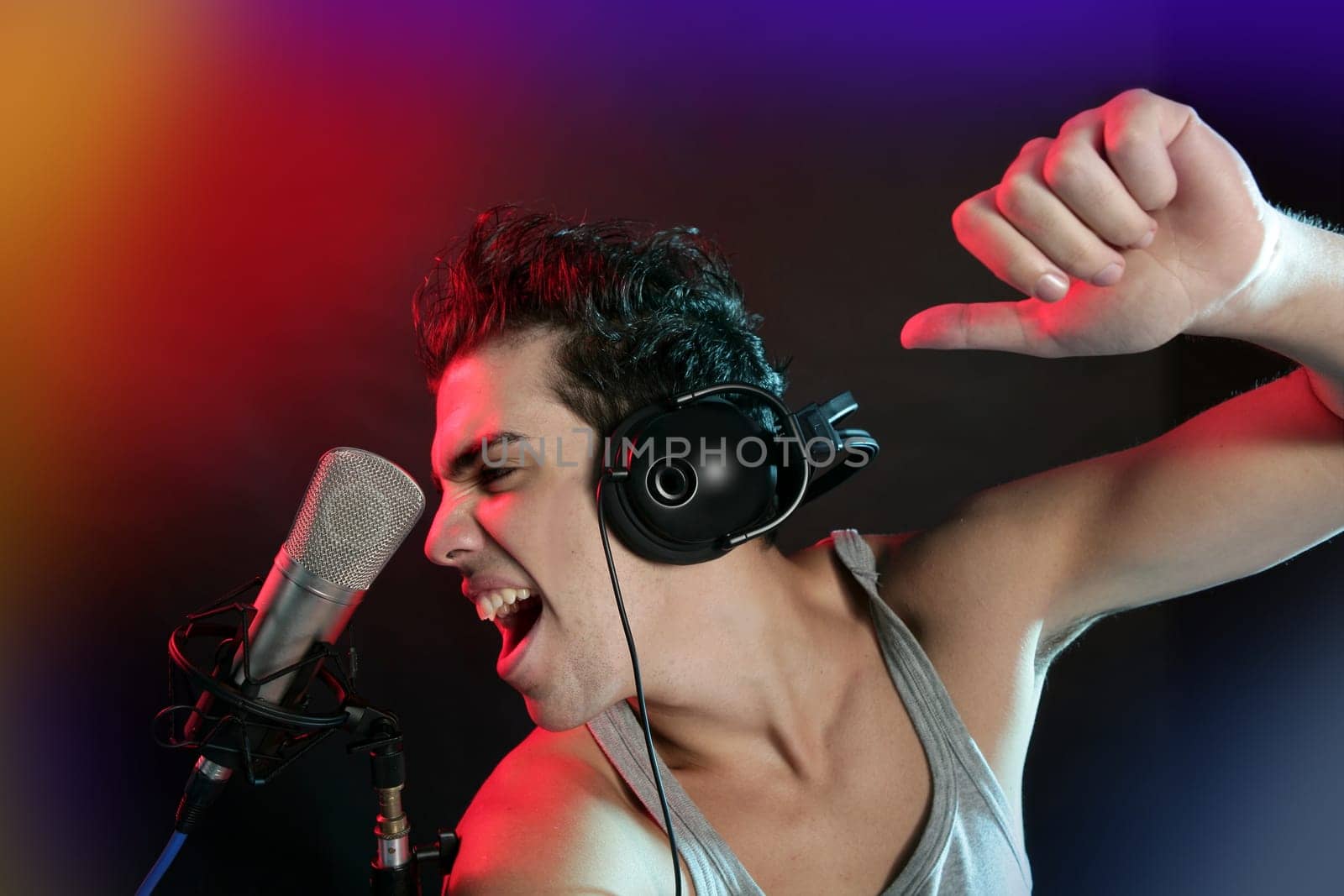 Dj with colorful light and music mixing digital equipment