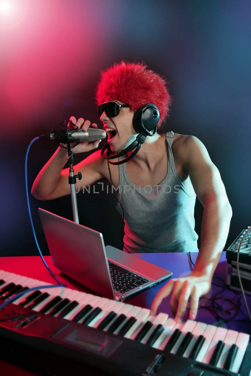 Dj with colorful light and music mixing digital equipment