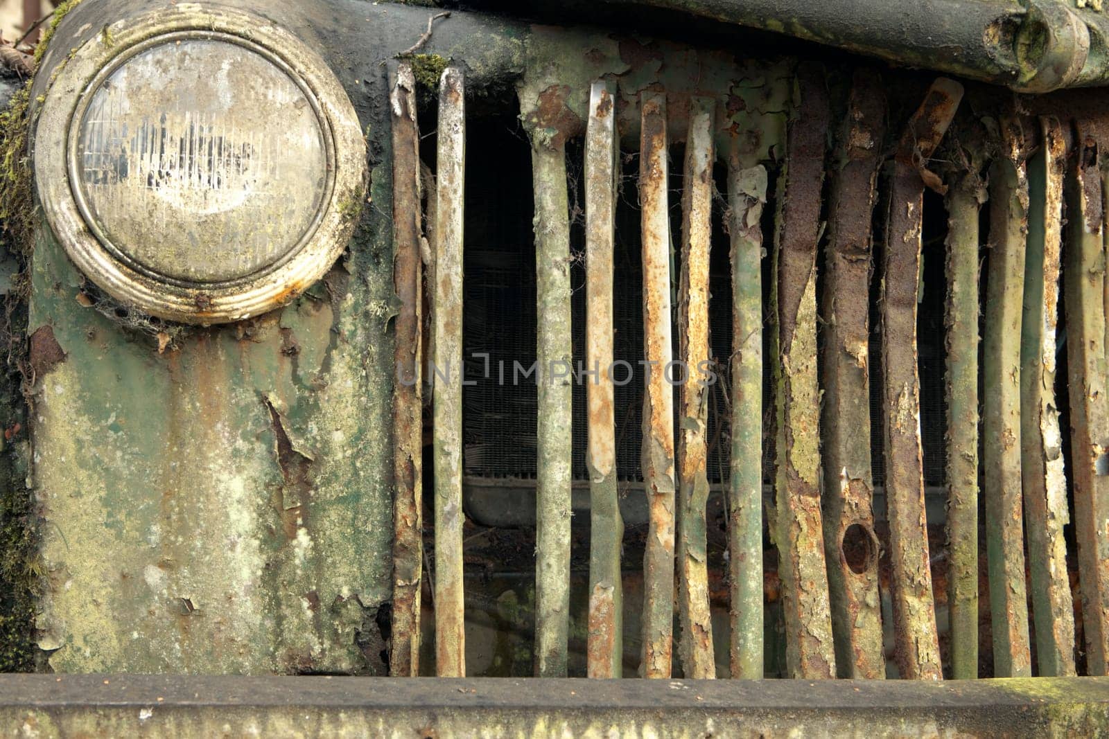 The exterior radiator grill from a old, abandoned and broken-down truck that has rusted out from top to bottom.