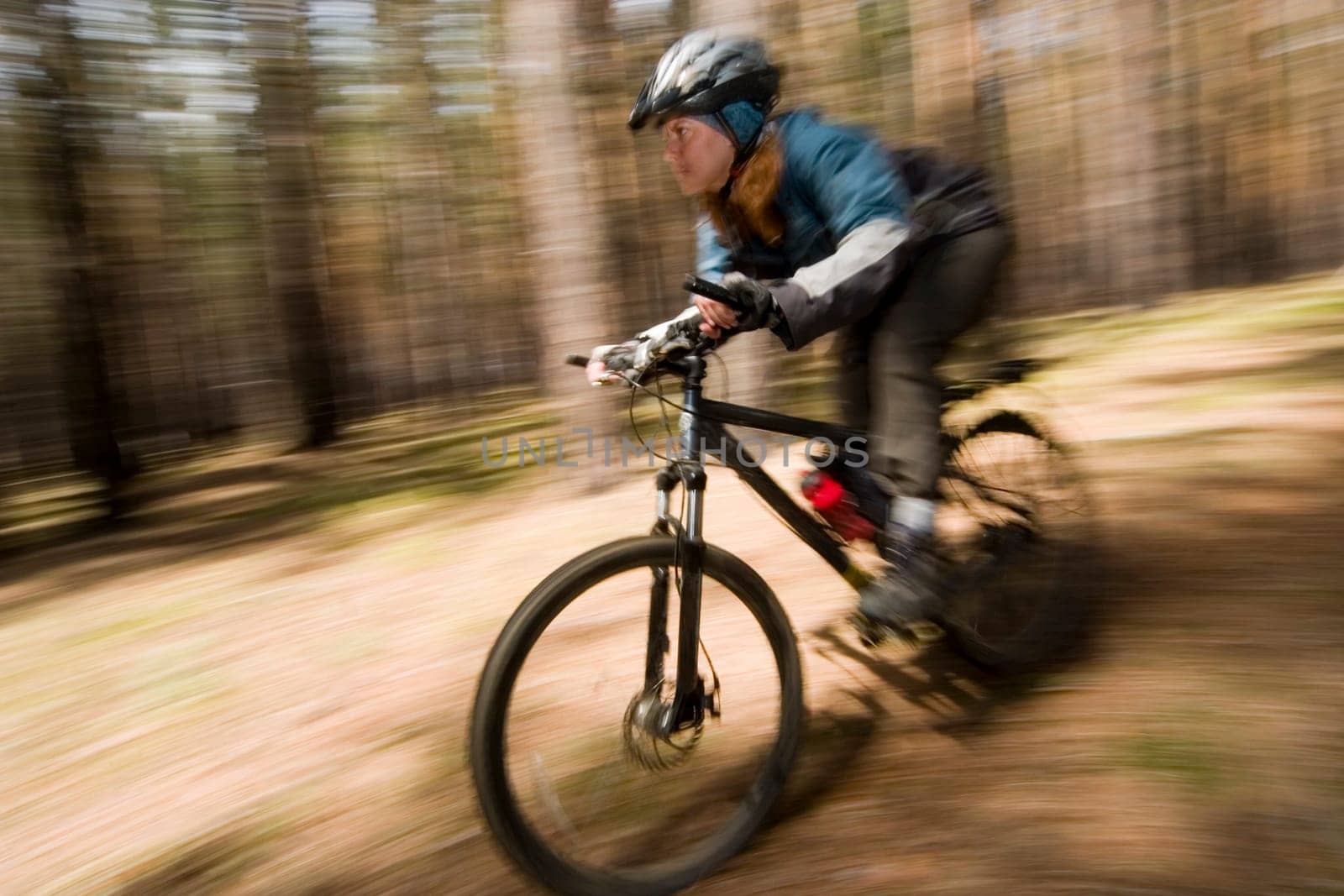 Woman-biker blurred in motion. Cross-country.