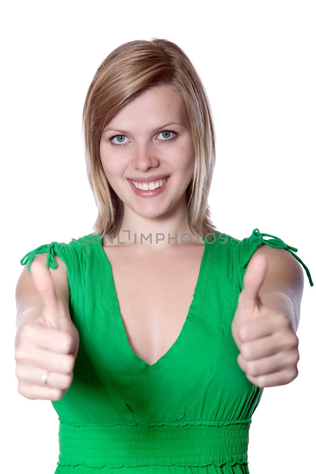 Joyful young woman in a green dress gives thumbs up