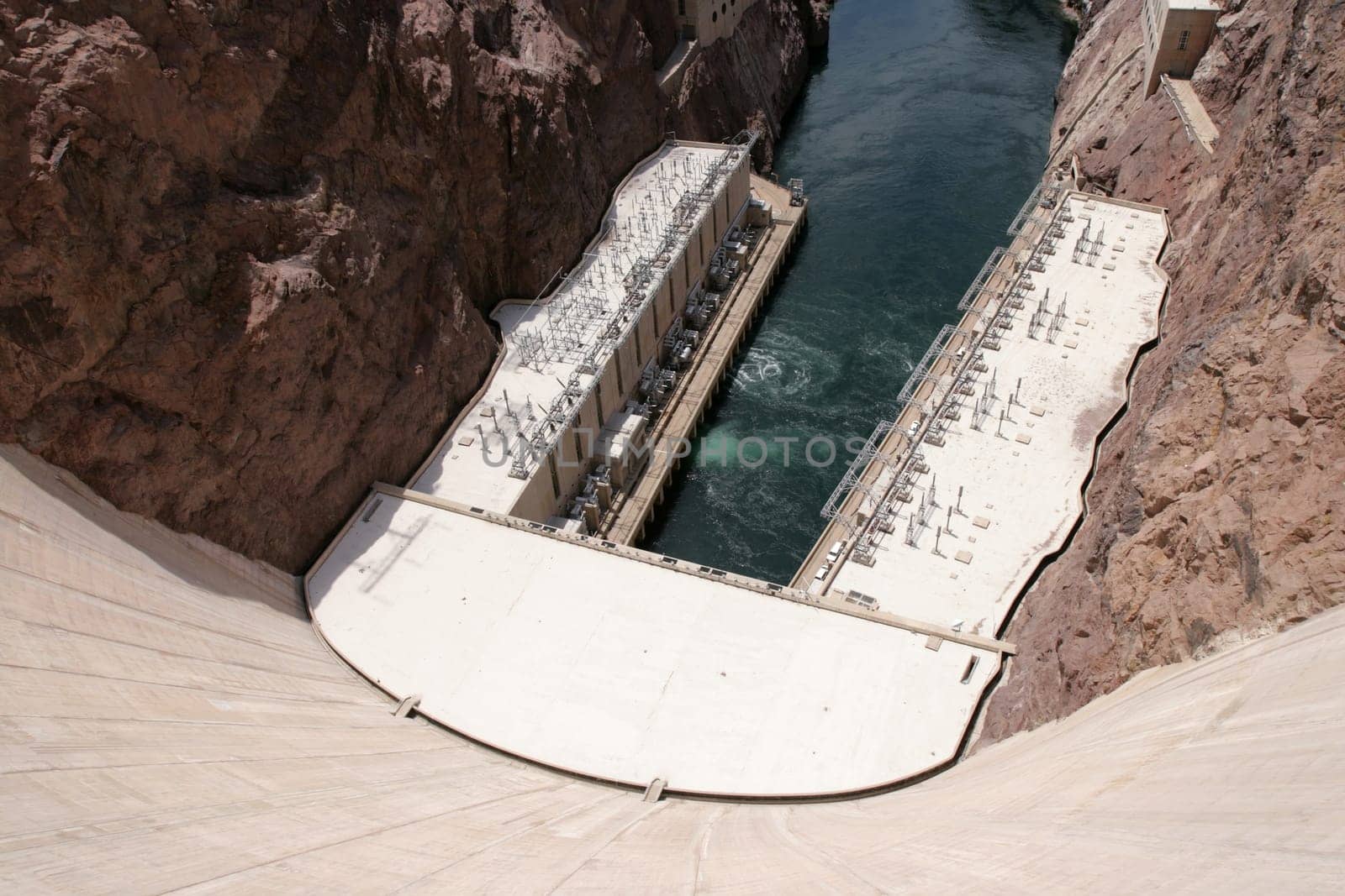 View of down Hoover Dam at hydroelectric powerplant and Colorado River.