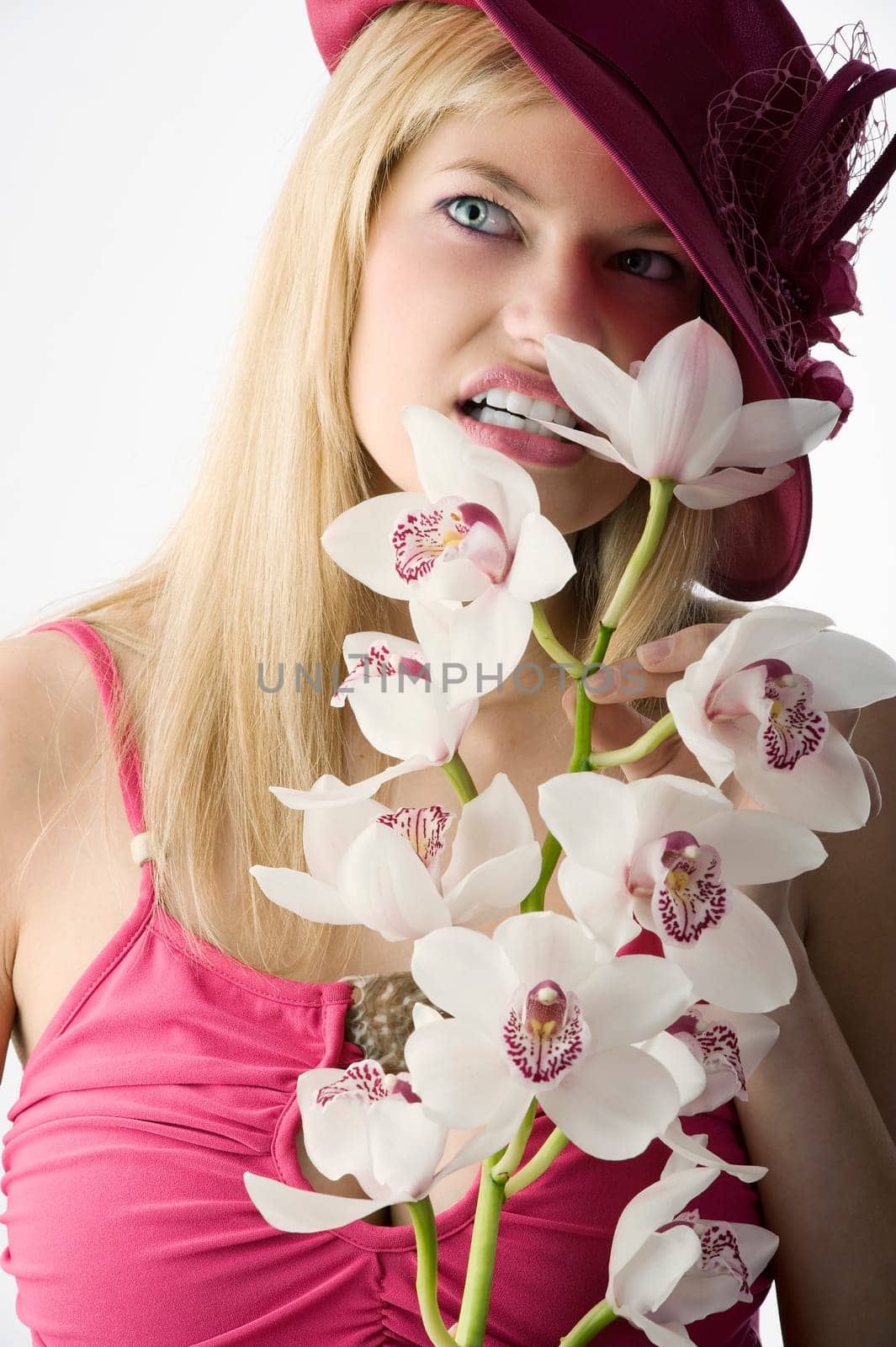 pretty girl with red hat biting an orchid and making face