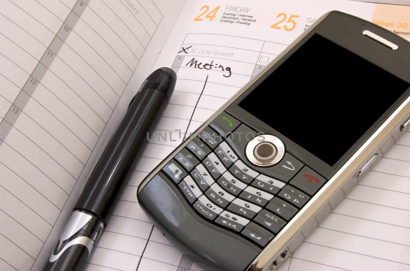 Business Planner showing a meeting on friday with a pen and a smart phone