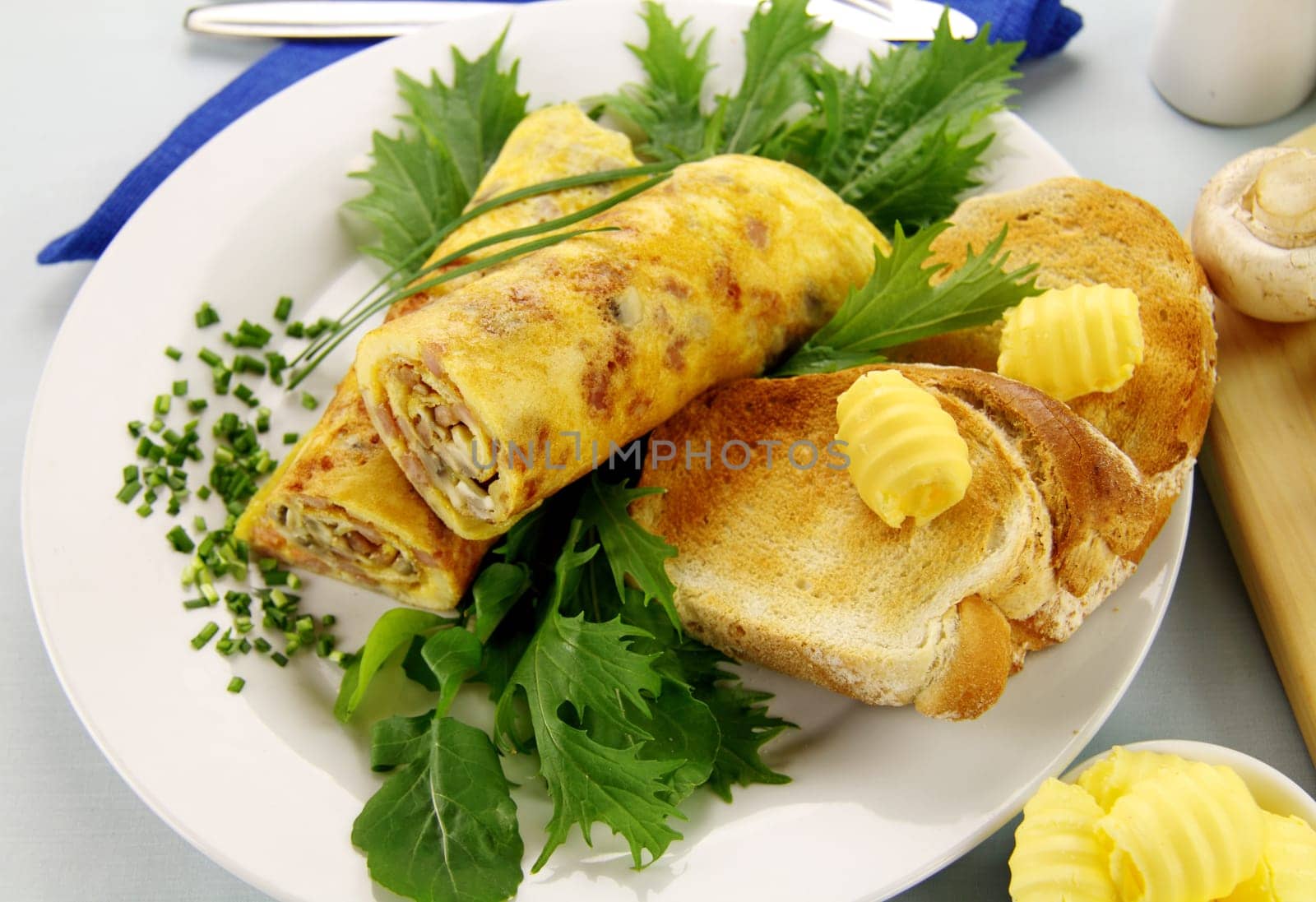 Delicious rolled mushroom and bacon omelette freshly prepared and ready to serve.