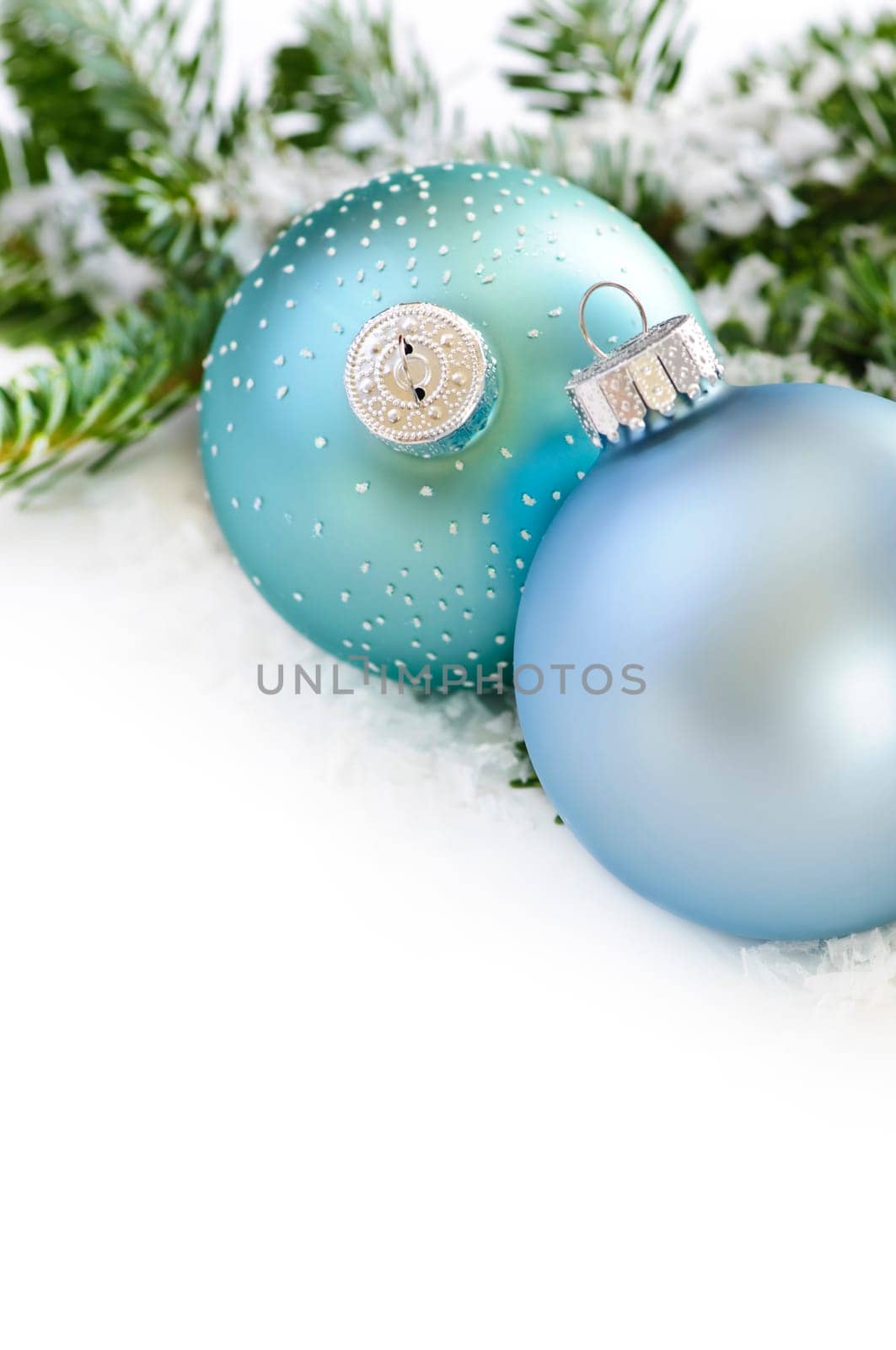 Two Christmas decoration in snow with pine branches
