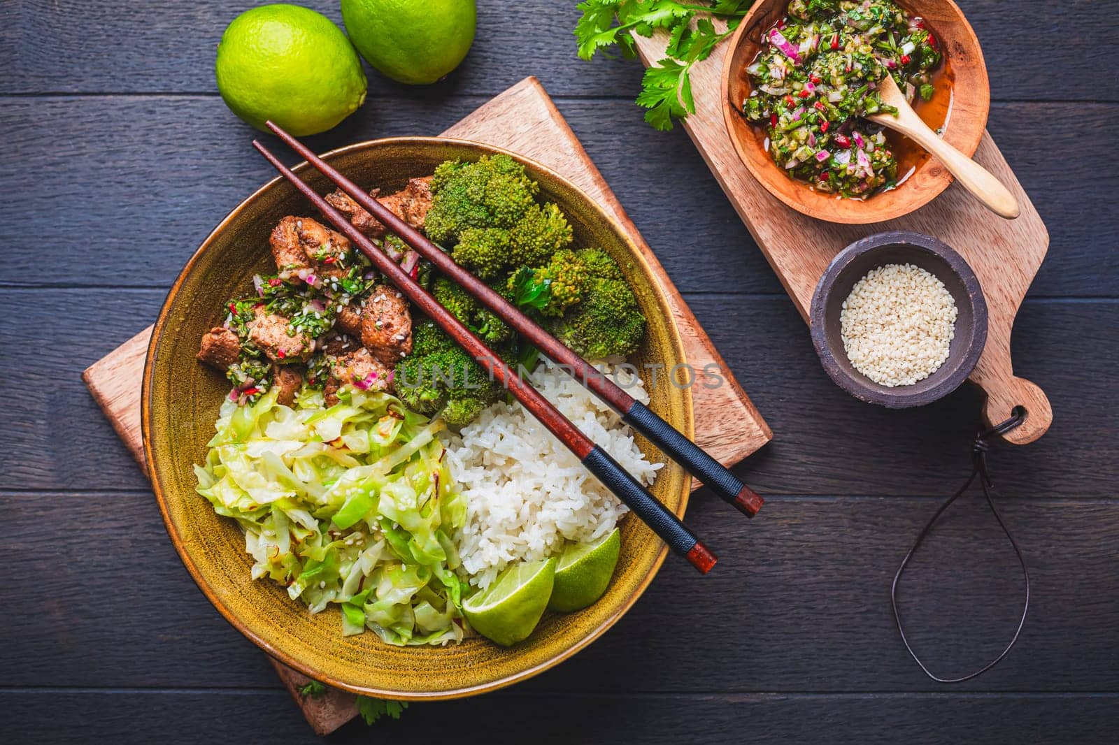 Chicken bowl with rice, broccoli, cabbage and green Chimmichurri salsa