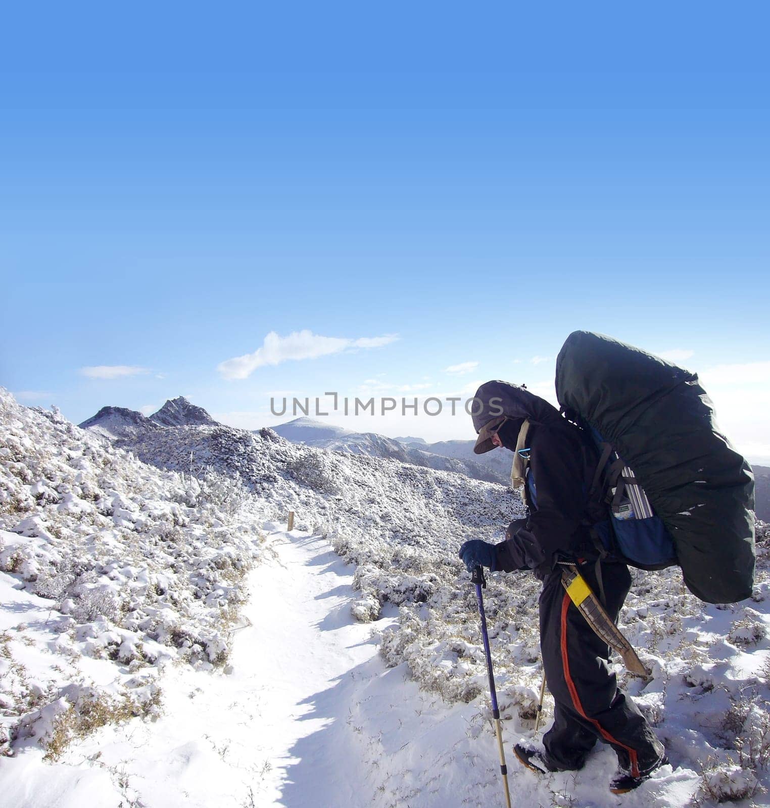 There was a backpacker with heavy pack walk on the snow.
