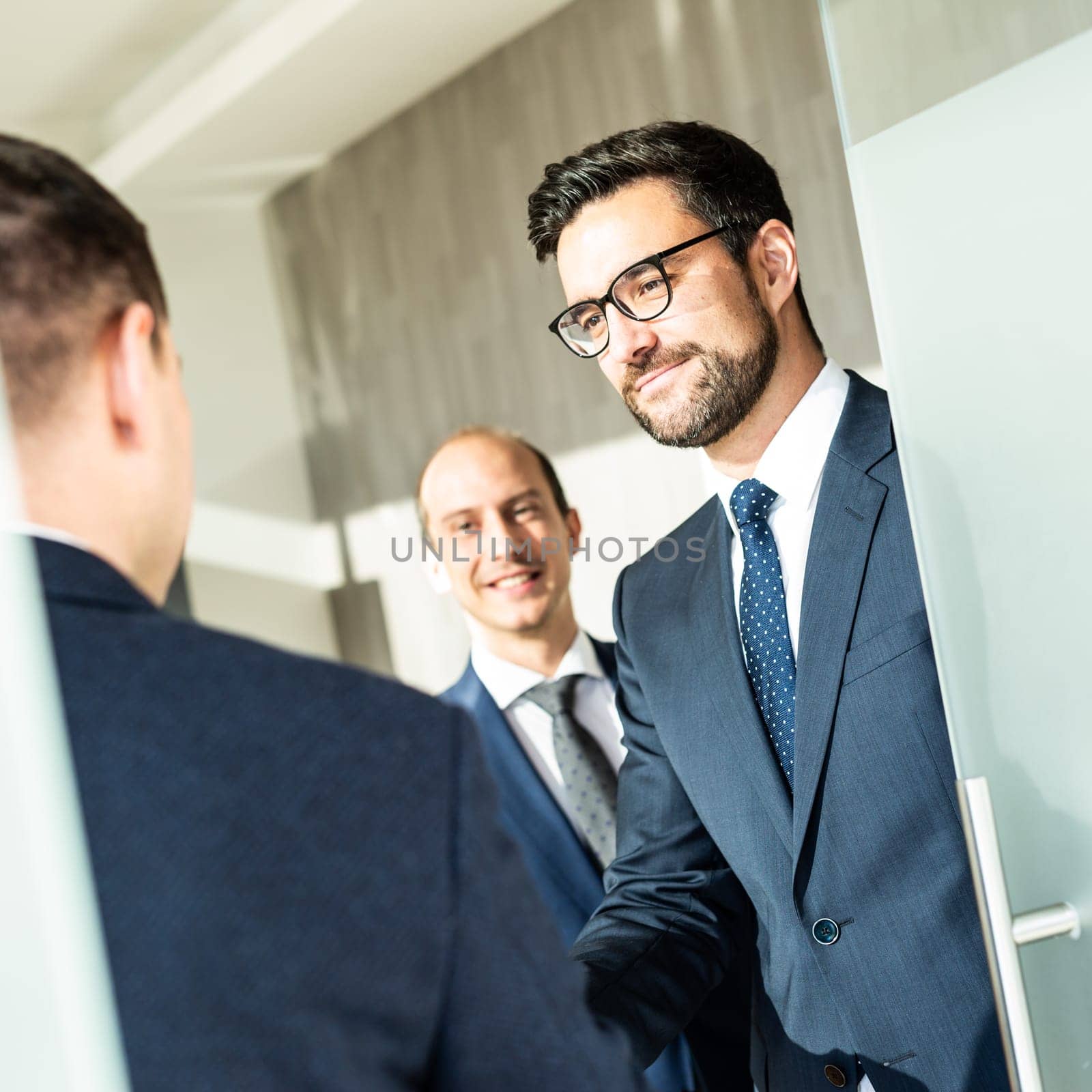 Group of confident business people greeting with a handshake at business meeting in modern office. Closing the deal agreement by shaking hands. Business and entrepreneurship success concept.