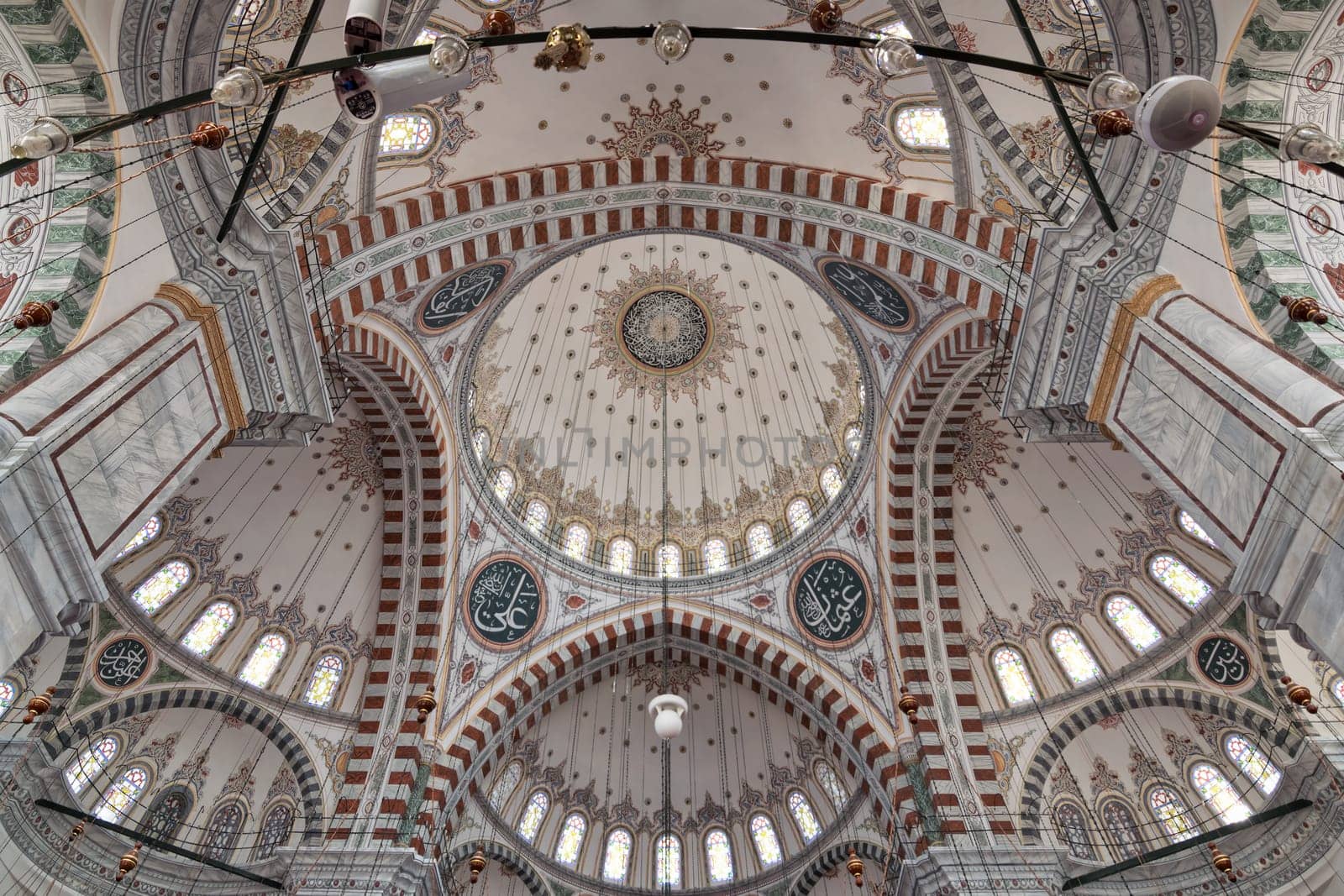 Ceiling of Ottoman Fatih Mosque in Istanbul, Turkey, made up of a series of decorated domes based on Islamic art. Calligraphy represent the names of the first four caliphs in Islamic era