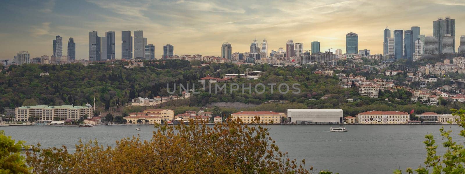 Aerial panoramic view from Fethi Pasha Grove overlooking Bosphorus and European side of Istanbul, Turkey at sunset, with green mountains and modern tall buildings