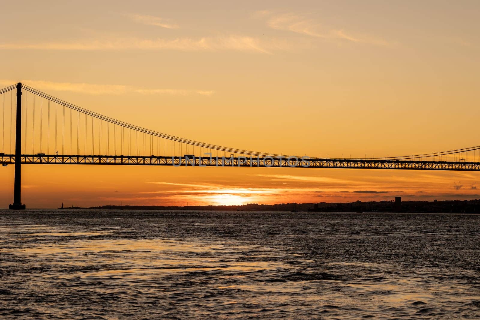 Suspension bridge over the sea at sunset. Mid shot