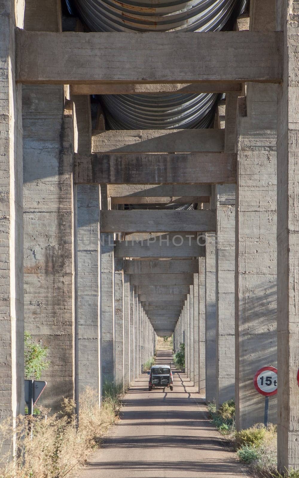 Vehicle crossing the road under Acedera Aqueduct, Vegas Altas del Guadiana, Badajoz, Extremadura, Spain
