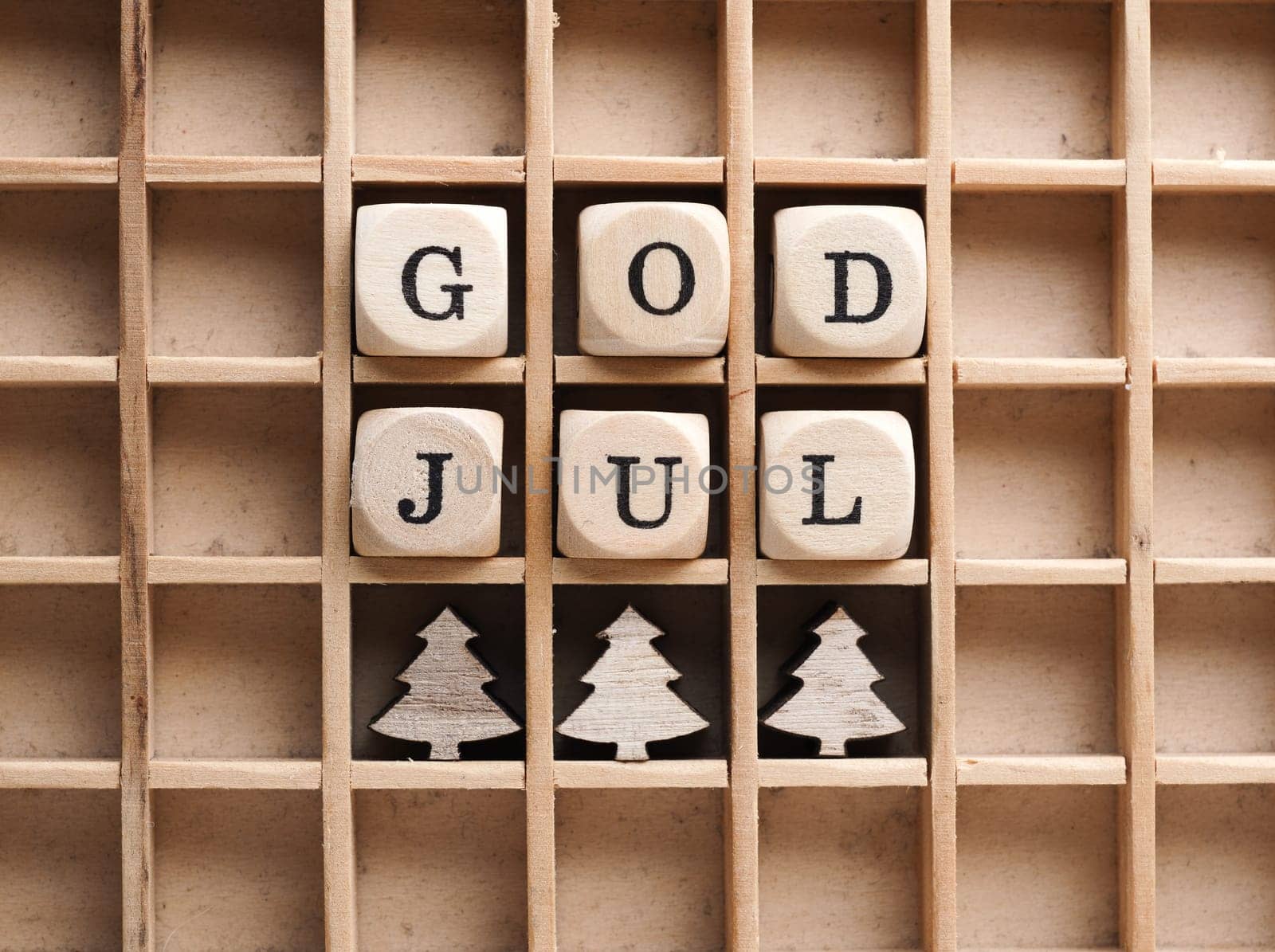 Small wooden blocks with the inscription God Jul, Scandinavian Merry Christmas, seasonal background with wooden tree shapes