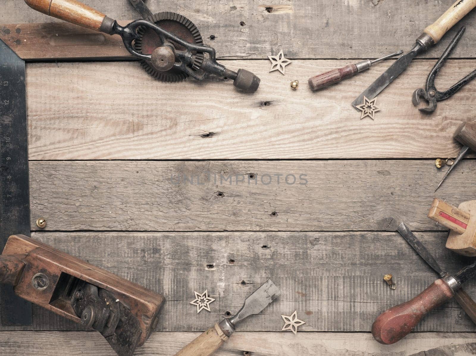 Vintage carpenter tools as a frame on a rustic wooden workbench with space for text, workshop concept