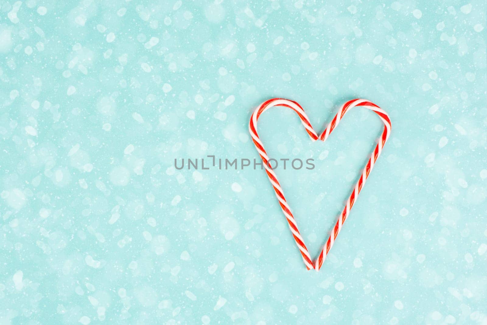 Candy cane forms heart shape, Christmas holiday background, winter season greeting card