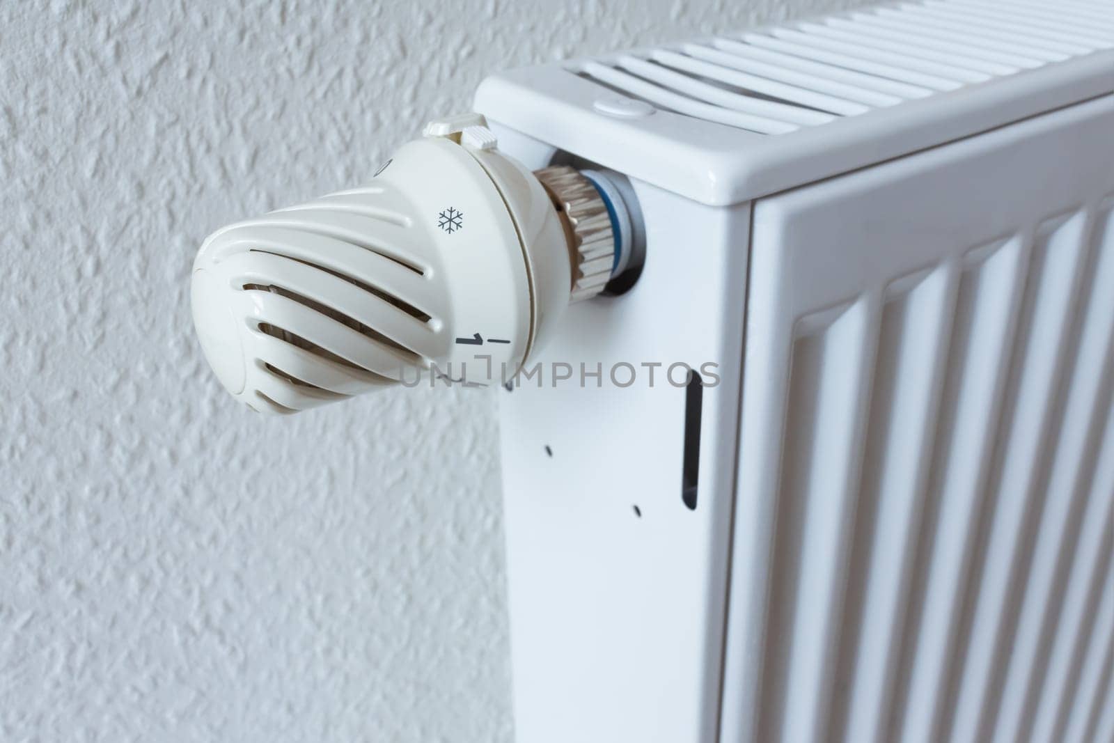 Detail of turned off thermostat, temperature knob of heating radiator. Saving energy and warm home concept, living costs.