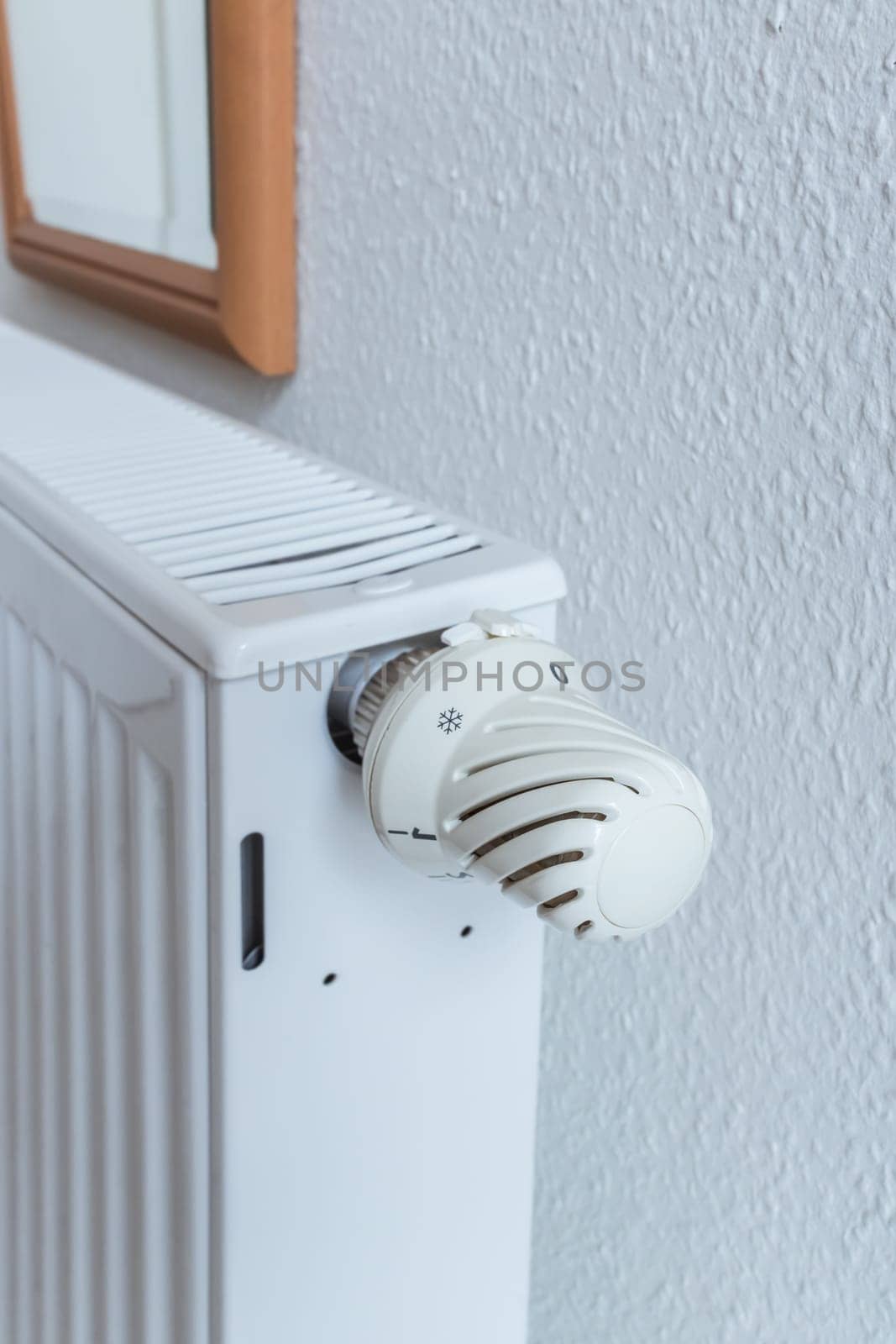Detail of turned off thermostat, temperature knob of heating radiator. Saving energy and warm home concept, living costs.