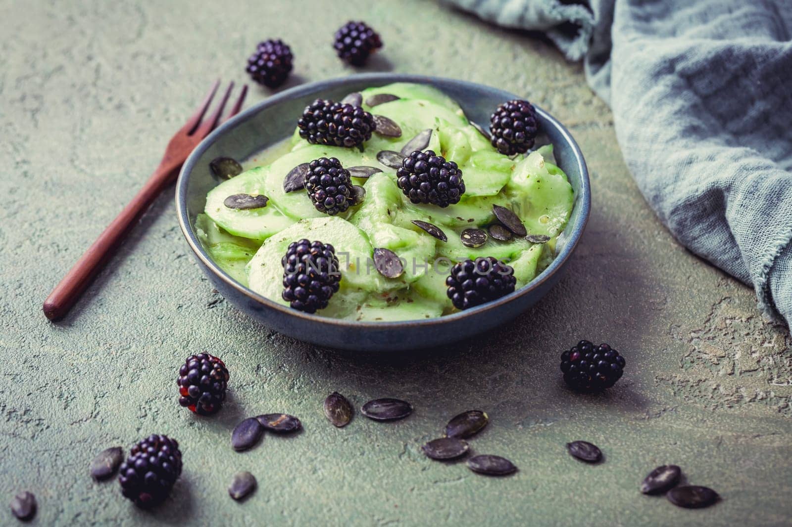 Cucumber salad with blackberries and yogurt dressing and seeds