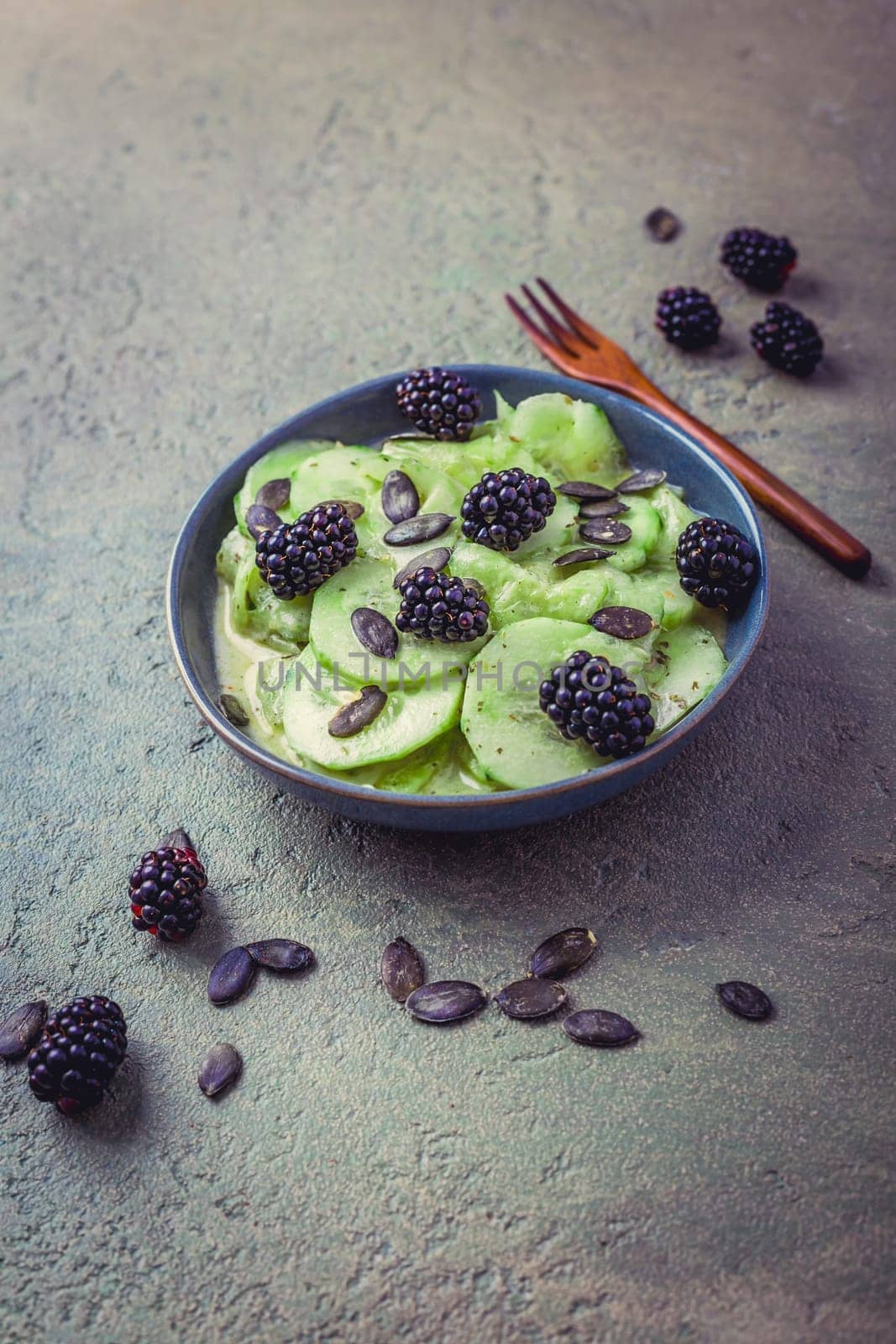 Cucumber salad with blackberries and yogurt dressing and seeds